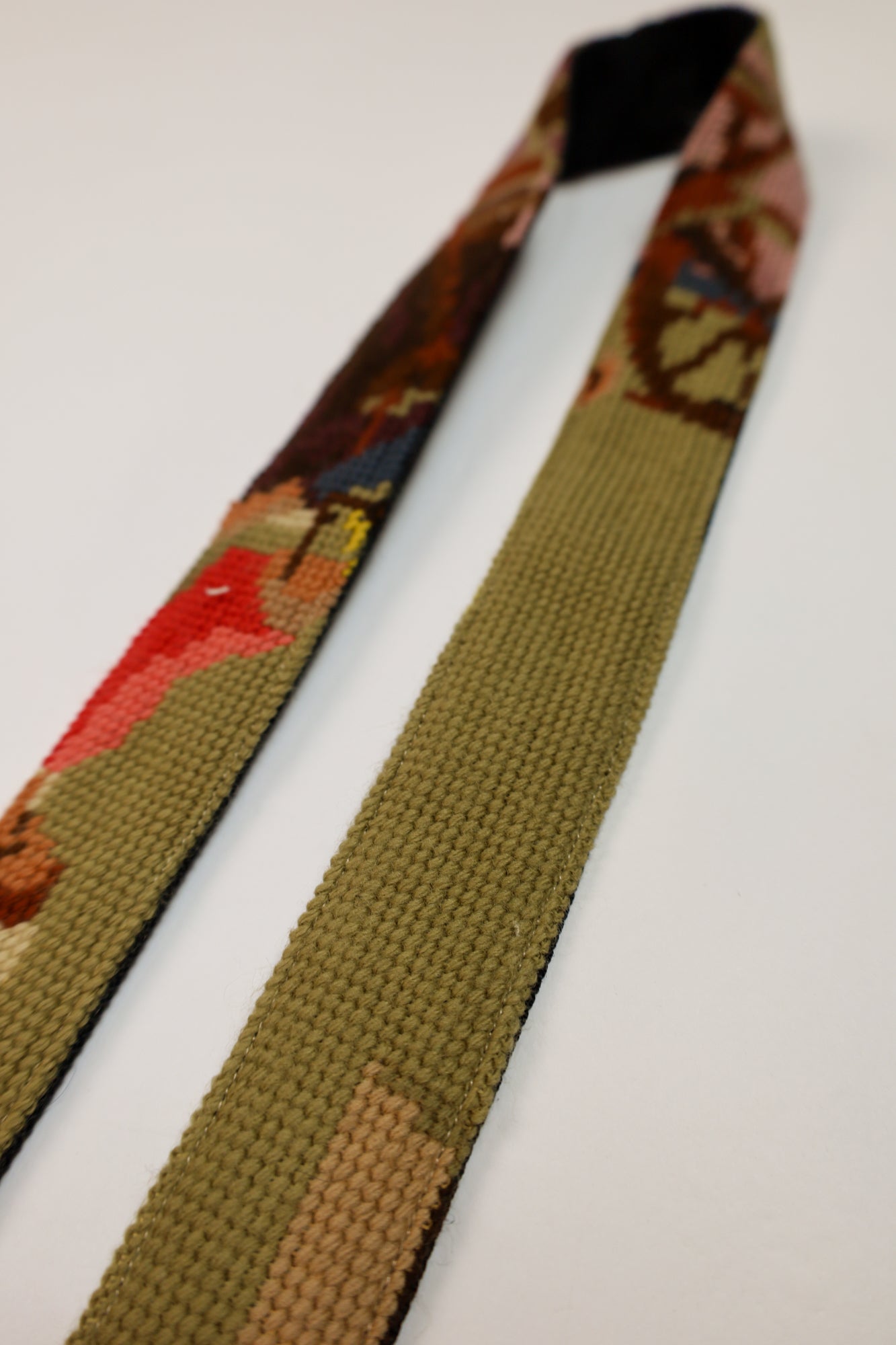 Unique strap with a colorful embroidered painting in natural tones and pink-purple accents, perfect for adding character to your accessories.
