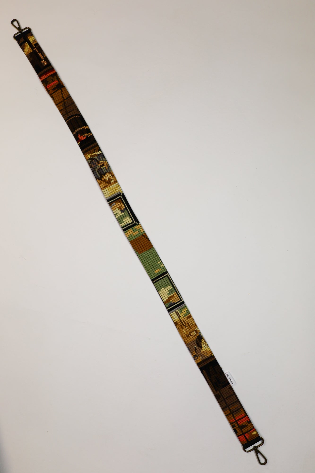 Sustainable strap in green, brown, and red tones, with embroidery depicting a hand-washing scene, suitable for bags, cameras, and phones.