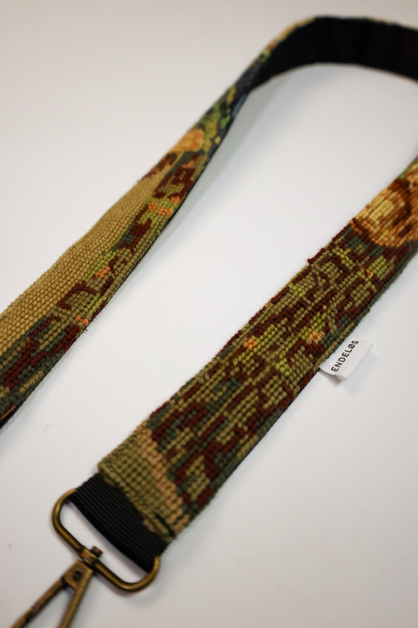 Close-up of a strap with embroidery in the style of The Last Supper, made from upcycled materials for a unique look.