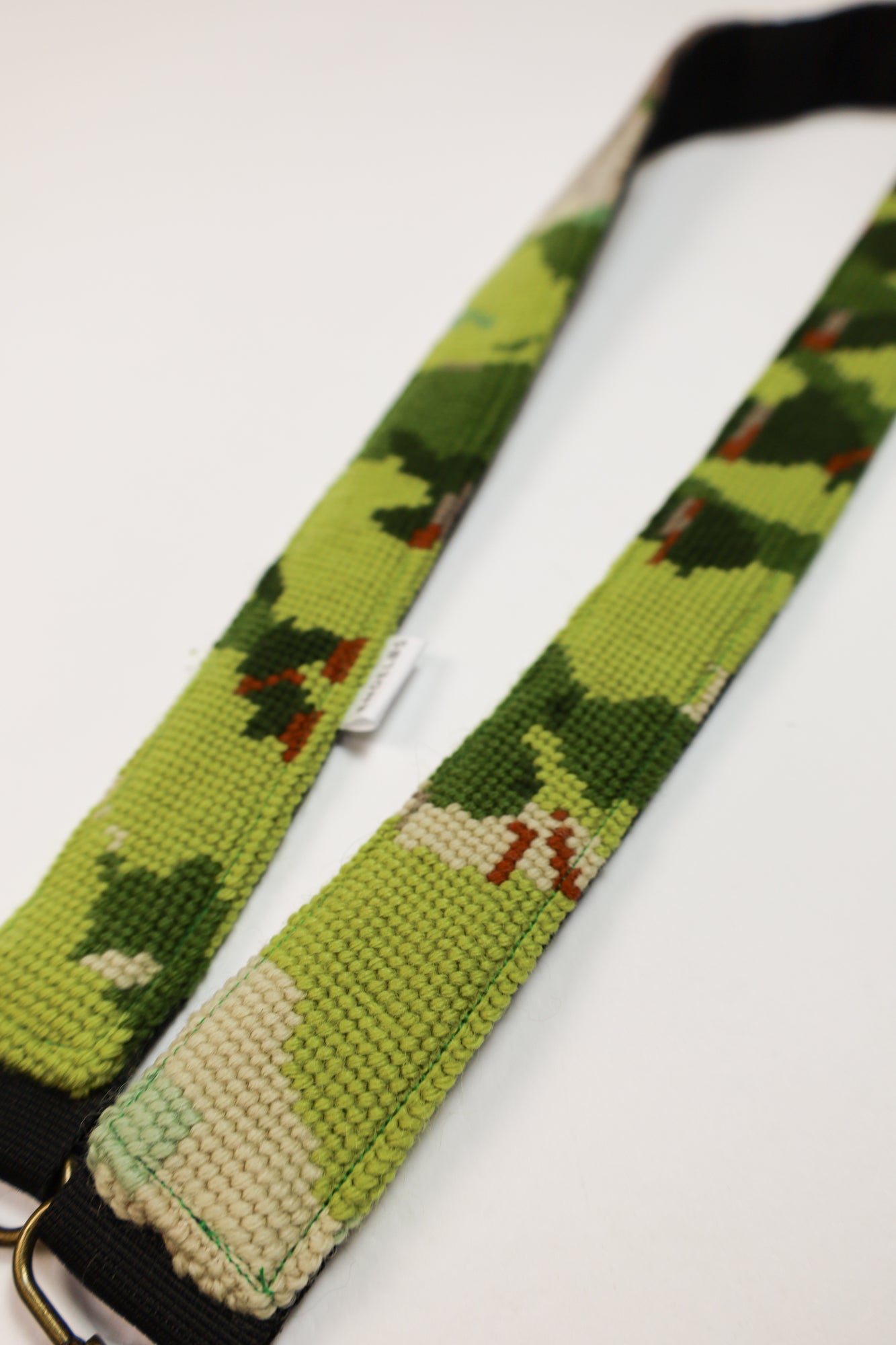 Close-up of a green embroidered strap, made from upcycled materials, ideal for a sustainable and unique addition to your accessories.
