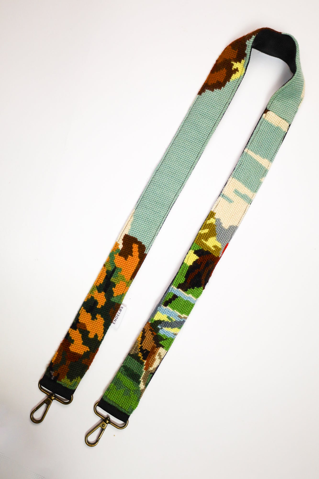 Close-up of a strap with an artistic hunting scene, executed in natural colors and made from upcycled materials