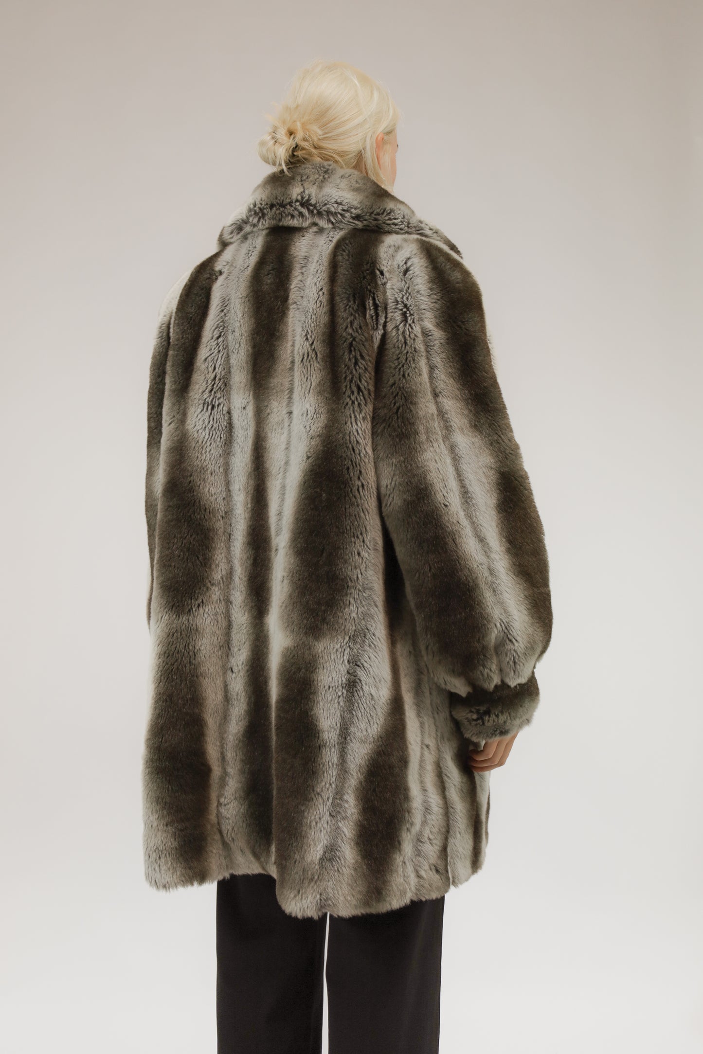 Model van achteren met vintage A-lijn faux fur jas in grijs-witte melange.