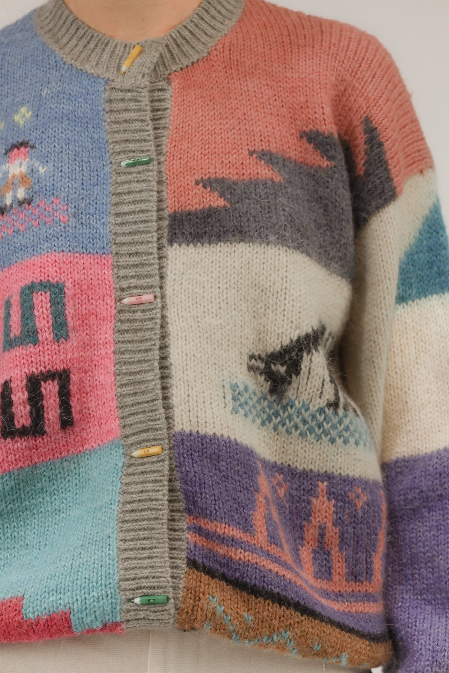 Detailopname van gebreide structuur en potloodknopen van het kleurrijke vest.