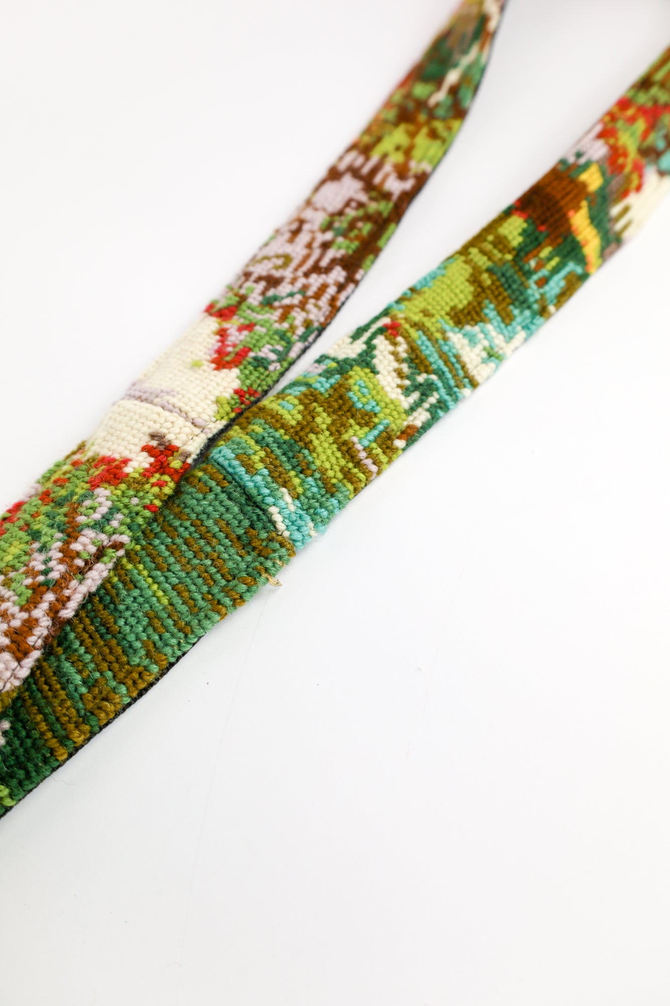 Handmade strap featuring an embroidered forest scene with natural colors and purple highlights.