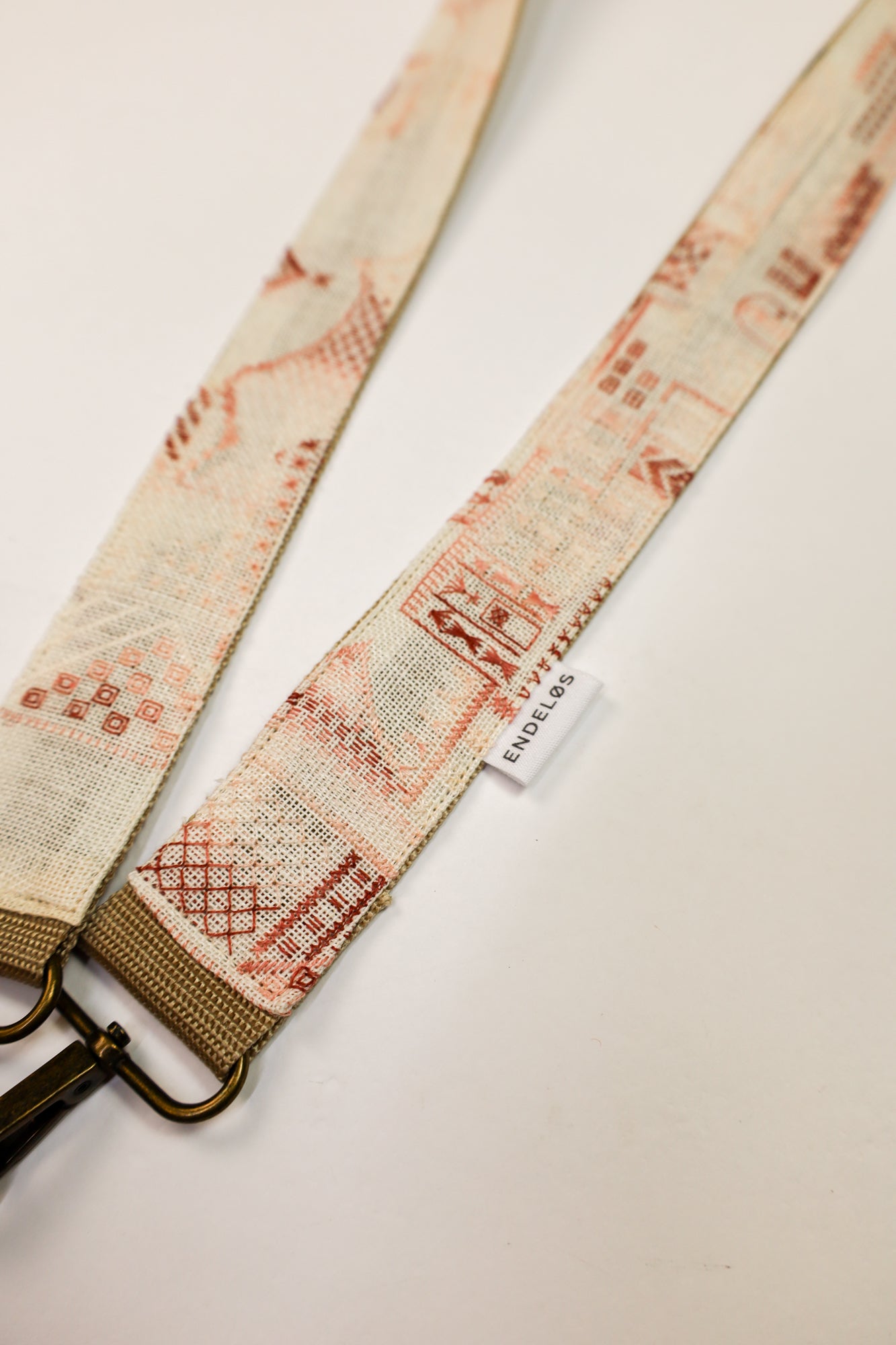Close-up van de tassenband gemaakt van vintage geborduurd schilderij, met delicate witte en roze borduursels.