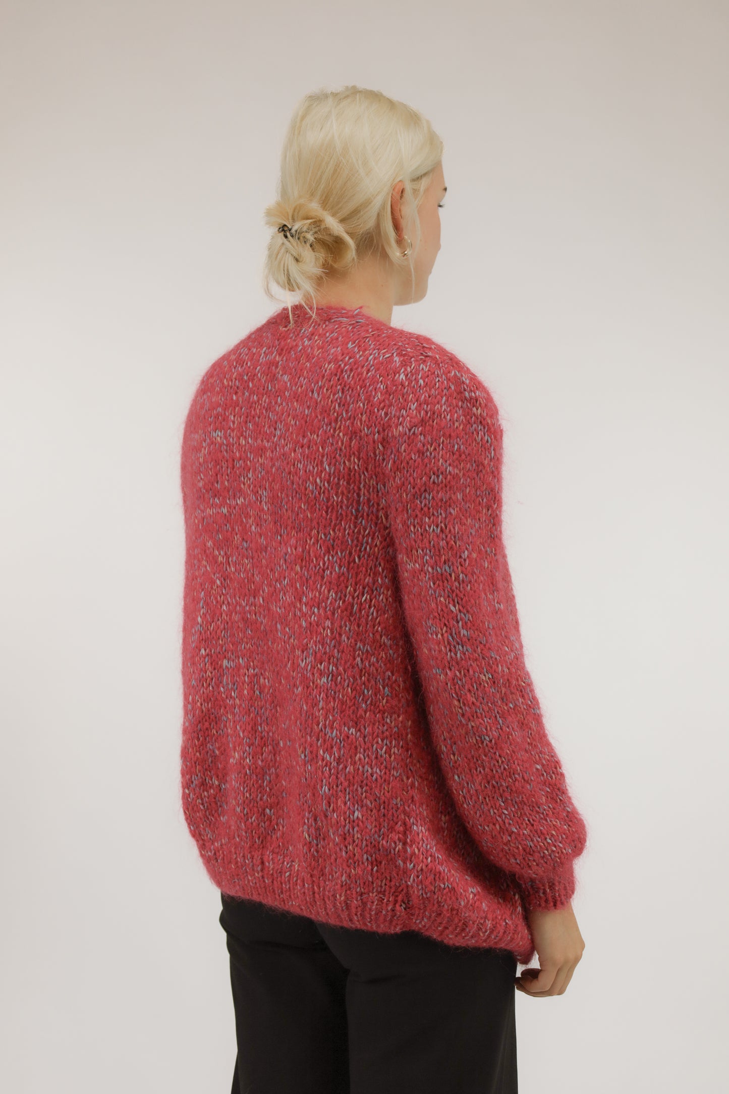 Model van achteren met oversized vintage vest in roze melange – losvallende pasvorm en cozy uitstraling.