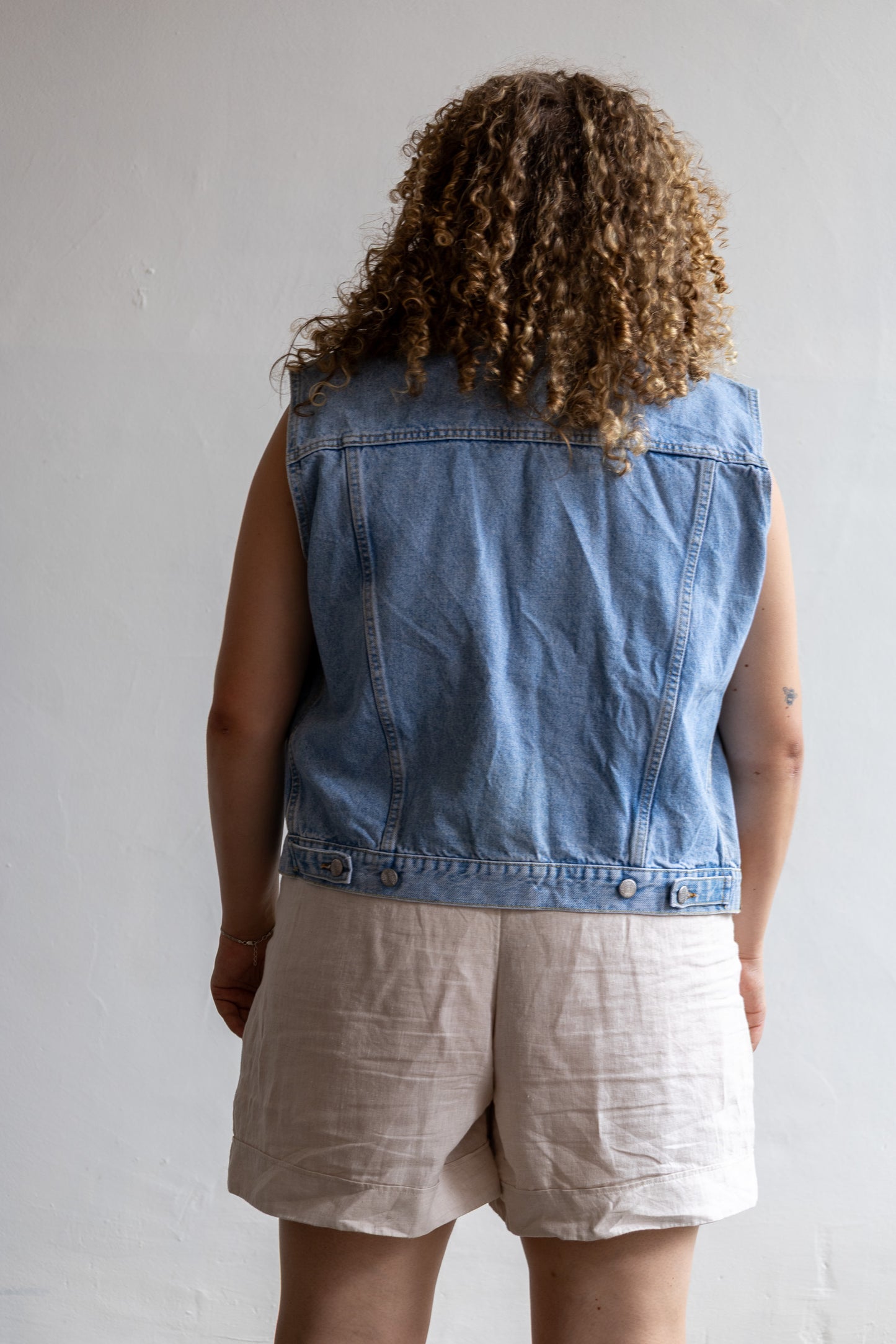 Achterzijde van het vintage oversized denim gilet met lichte wassing.