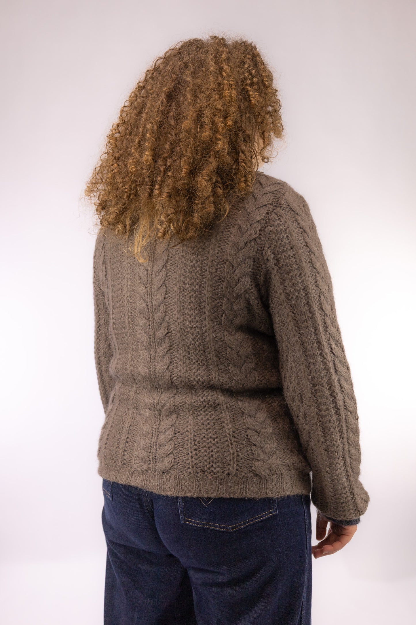 Achteraanzicht van vintage bruine voorjaar kabeltrui