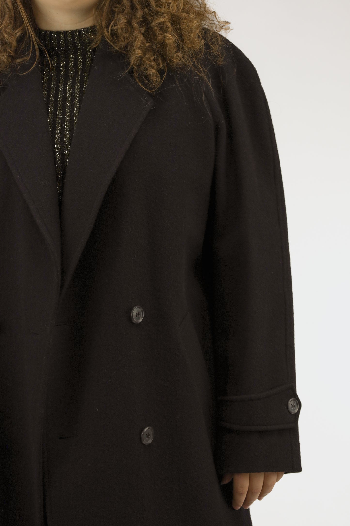 Detail van wollen stof en double-breasted knopen van zwarte vintage mantel