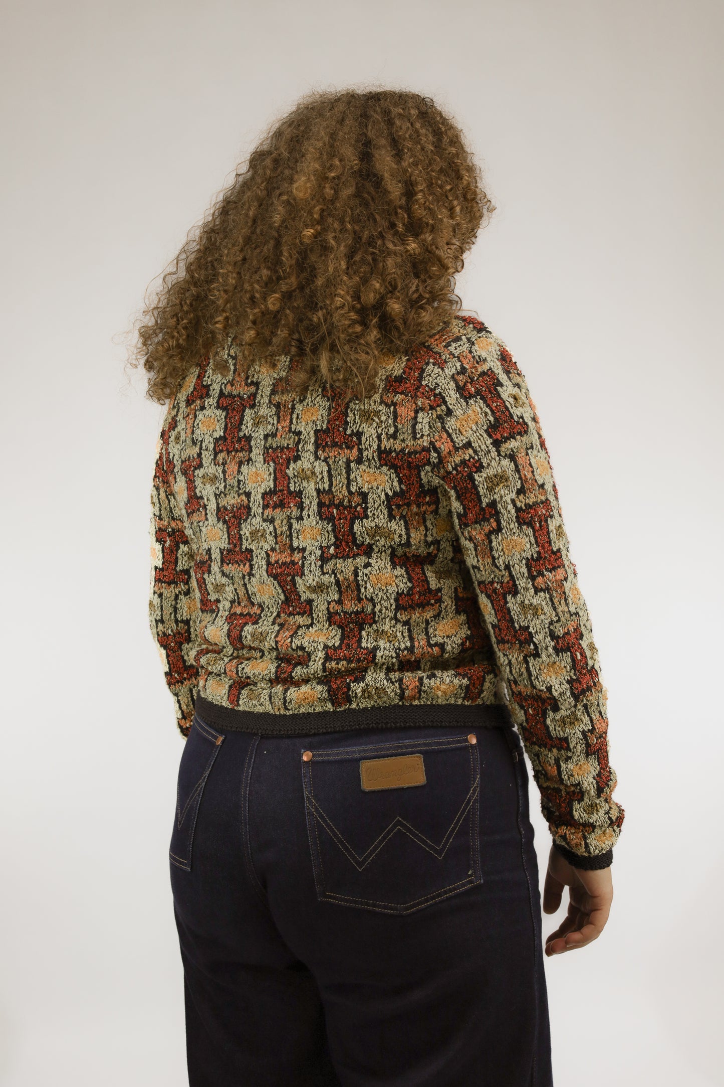 Achteraanzicht van handgebreid oversized vintage vest met geometrisch design