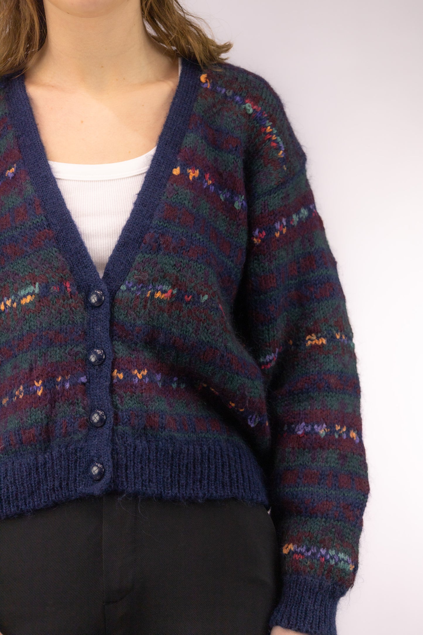 Detail van zacht handgebreid vest in mohair acryl mix met pluizige textuur en kleurverloop