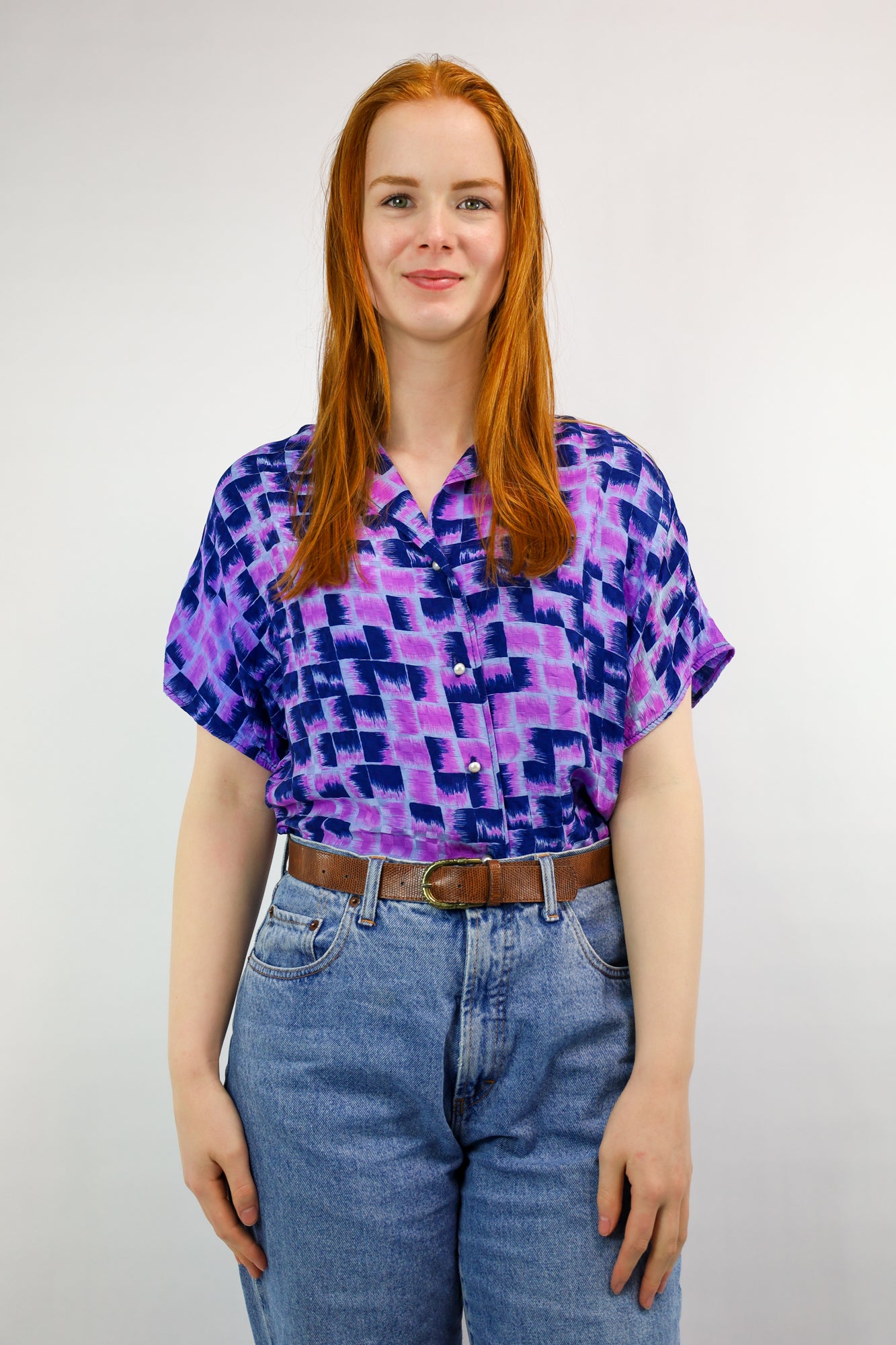 Voorkant van vintage blouse met paarse en blauwe grafische print en parelknopen