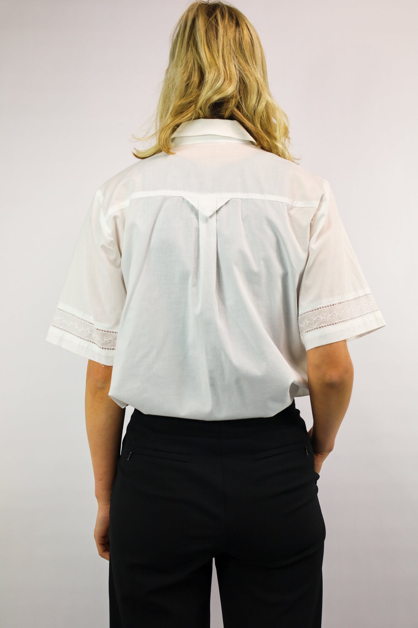 Achterkant van crispy witte blouse van katoen met fijne afwerking