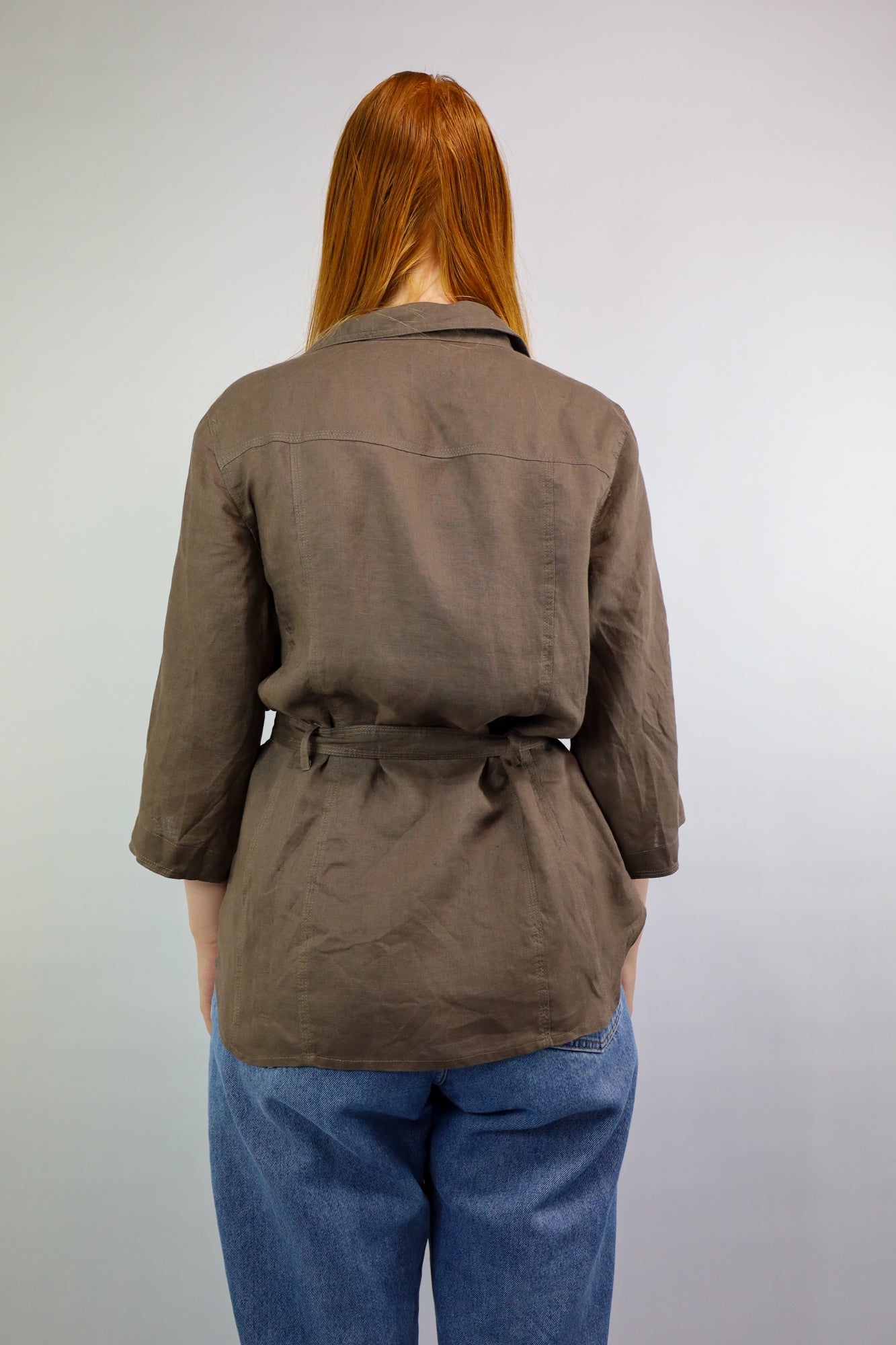 Achterkant van langer blousemodel tot op de heup in warme bruintint