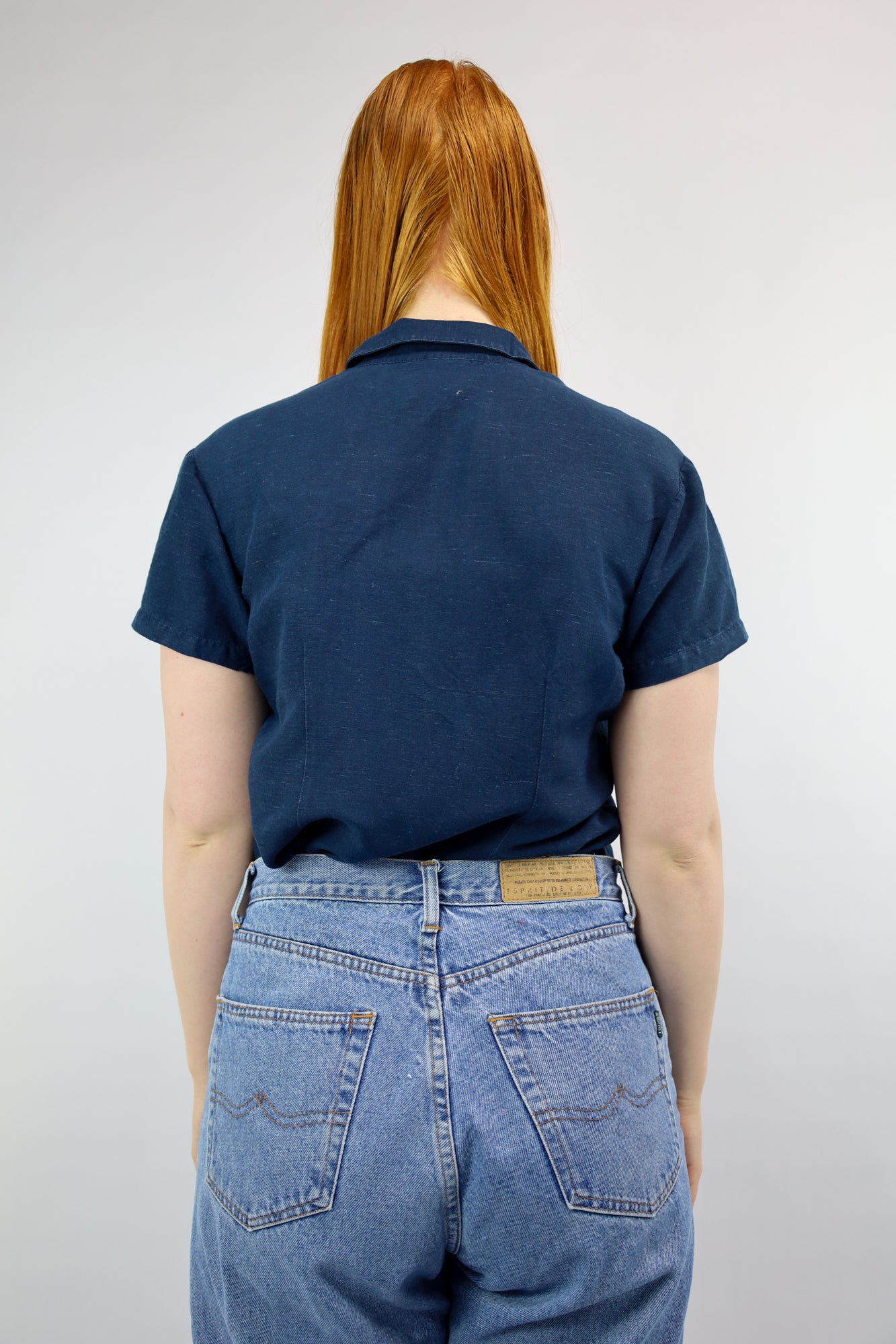 Achterkant van aansluitende blouse in donkerblauw met klassieke snit