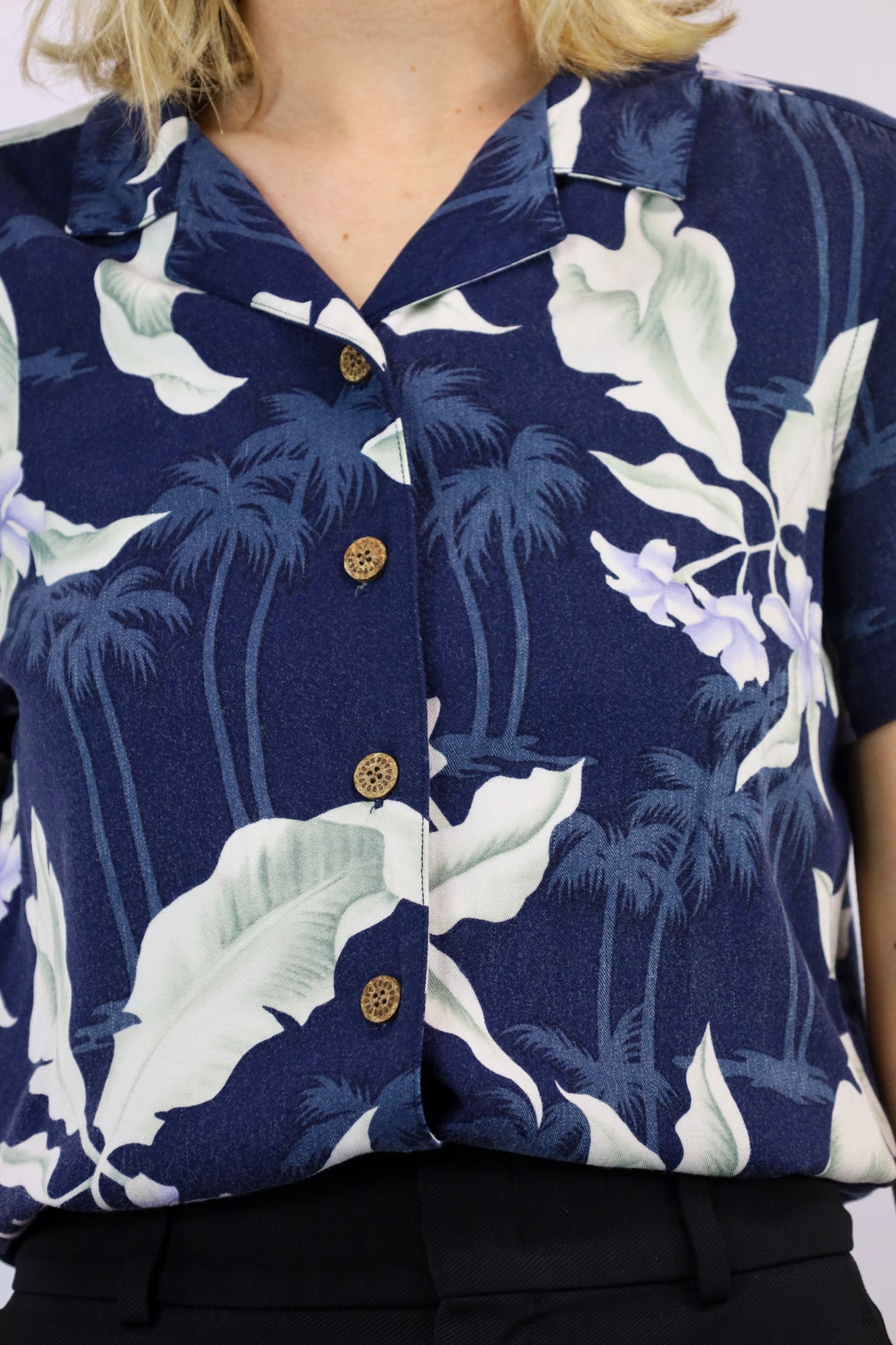 Detailopname van houten knoopjes en stevige stof van de blouse.