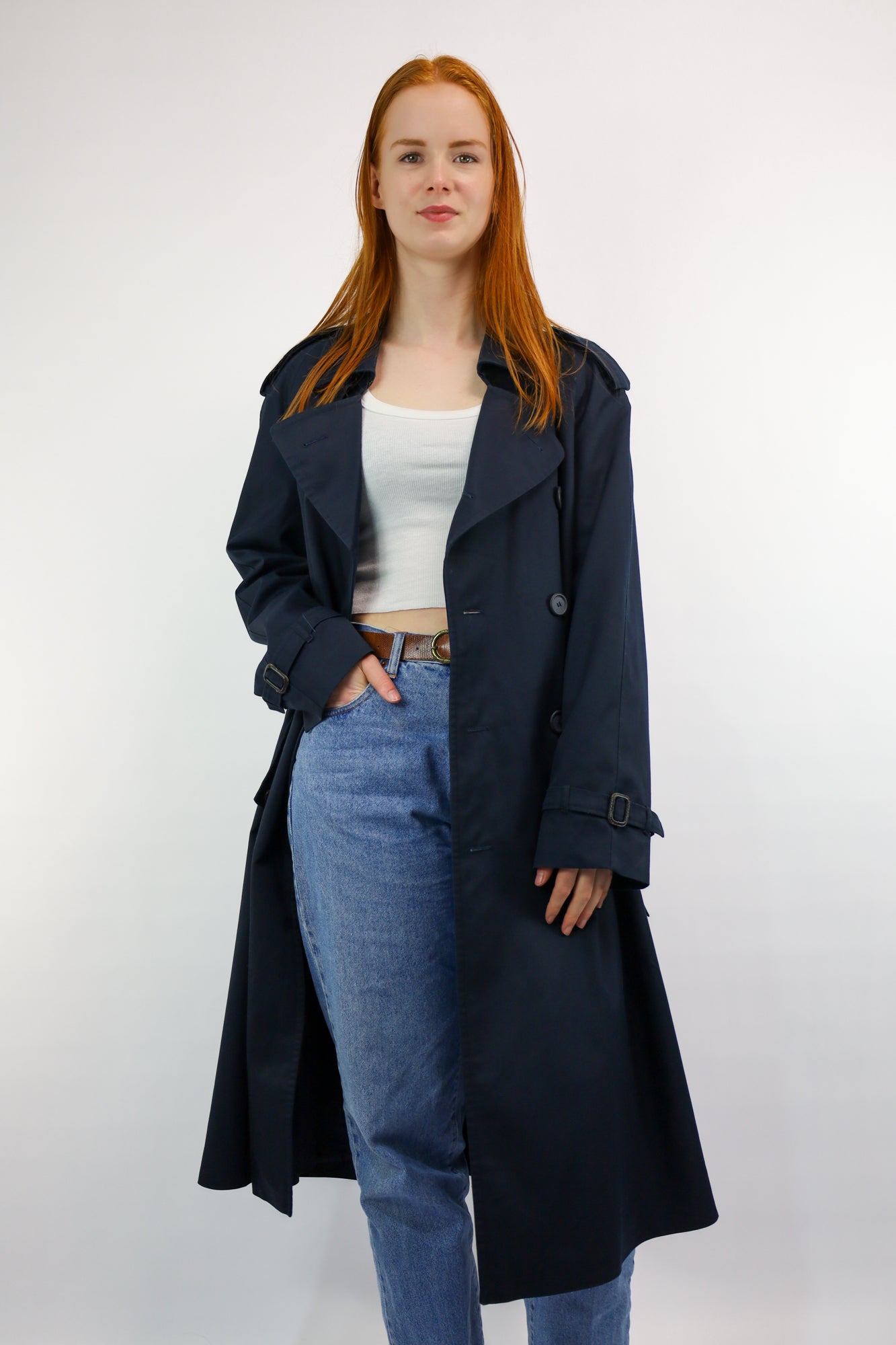 Tijdloze donkerblauwe trenchcoat met epauletten, ceintuur en vintage uitstraling