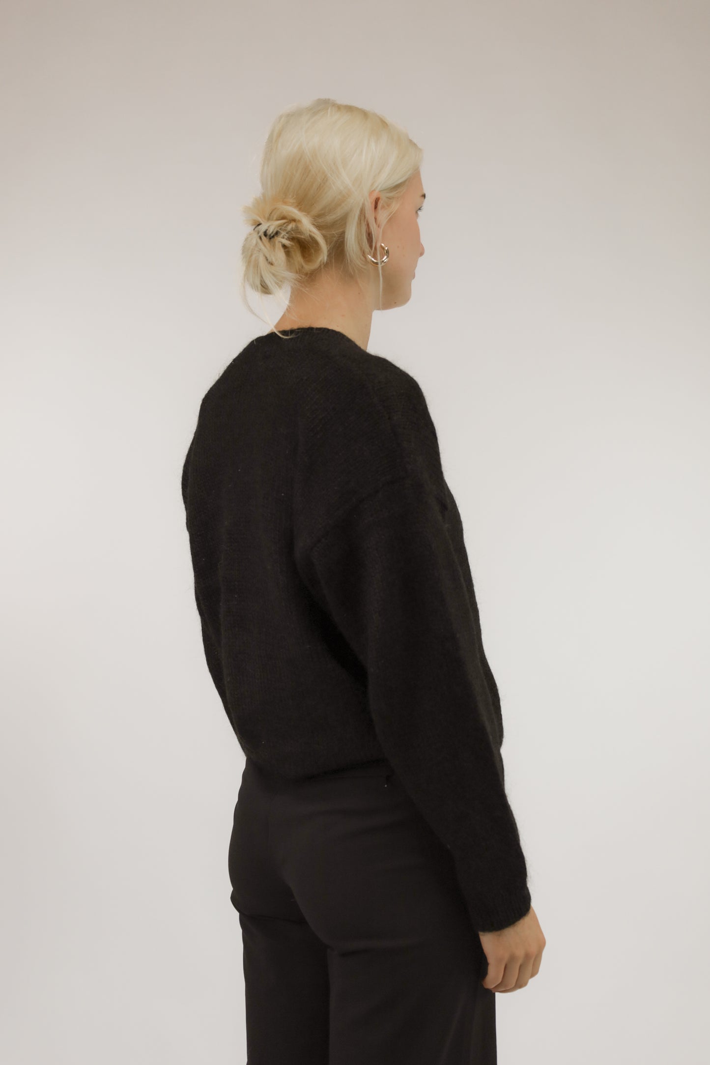 Model van achteren met zwart mohair-acryl vintage vest – basic fit en tijdloze uitstraling.