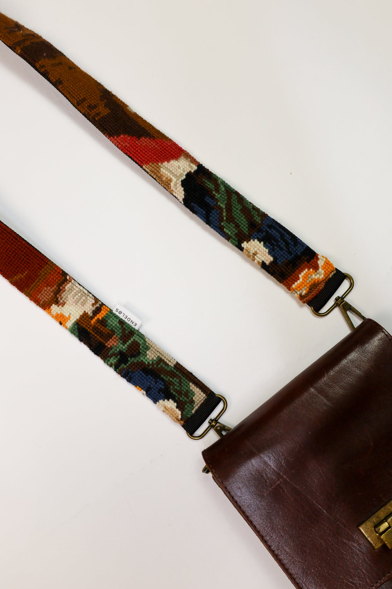 Strap geïnspireerd op het schilderij De Goudweger, met bruin, groen, blauw, wit en gele tinten.