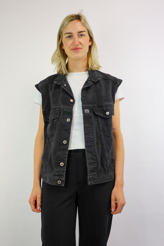 Voorkant van een donker vintage mouwloos denim vest in zwart met borstzakken.