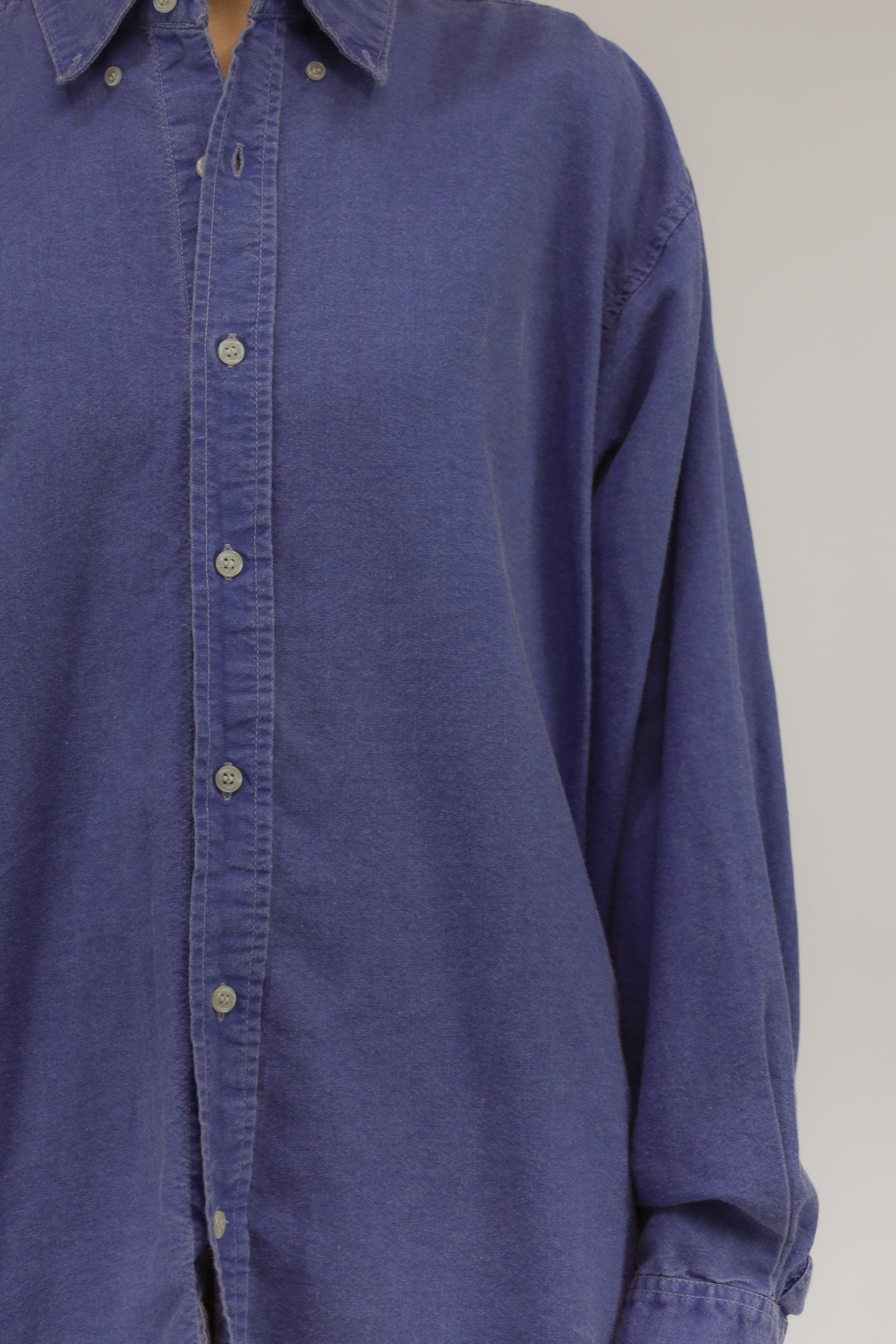 Close-up van model met vintage katoenen blouse – detail van stof met denimlook en lichte wassing.