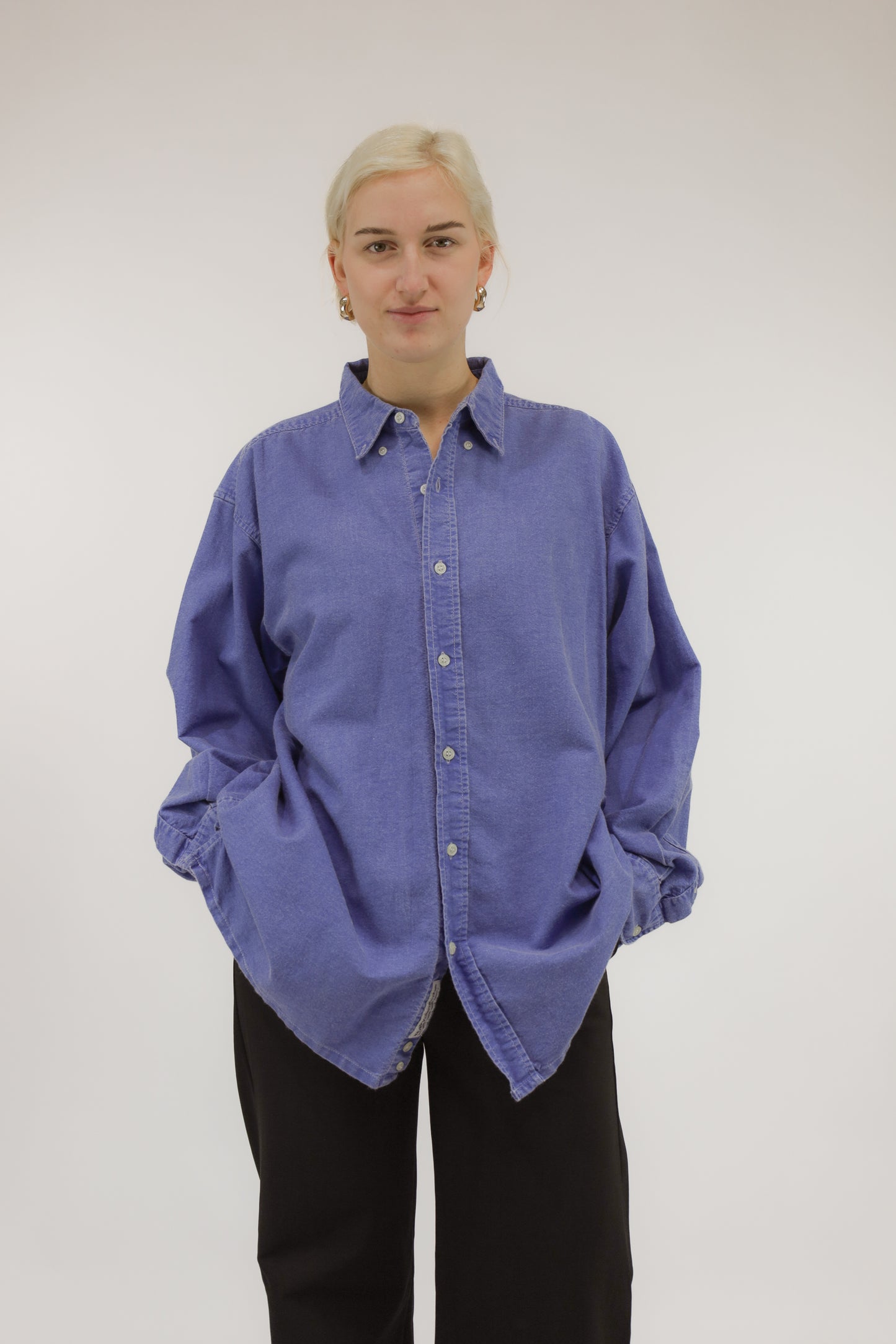 Model draagt vintage oversized katoenen blouse met denim verwassen effect – vooraanzicht.