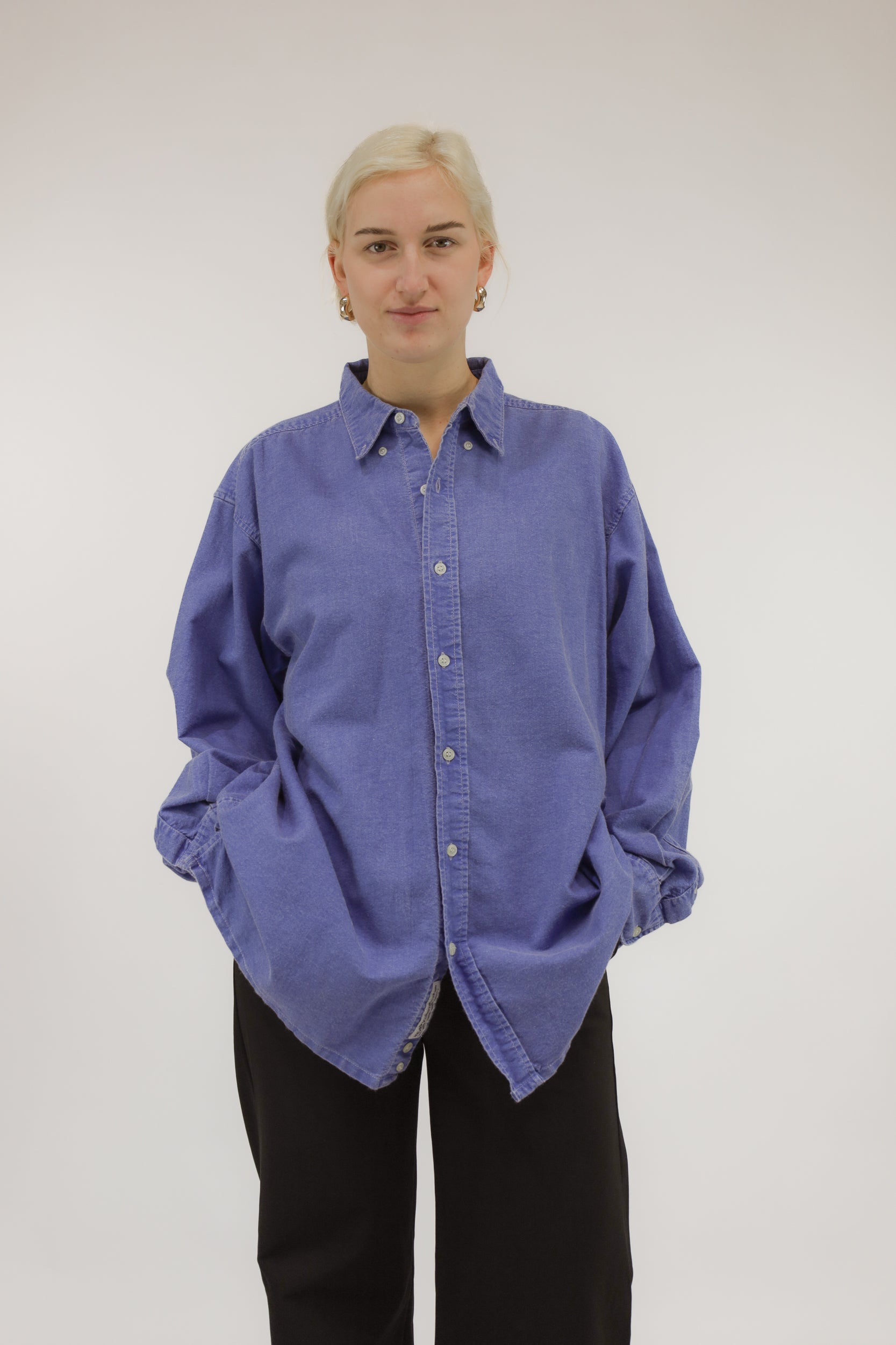 Model draagt vintage oversized katoenen blouse met denim verwassen effect – vooraanzicht.