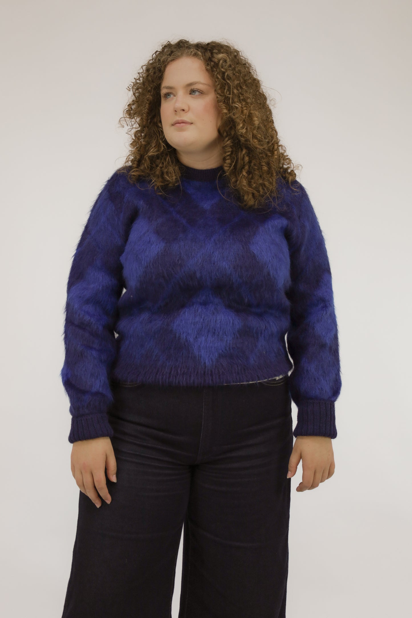 Vooraanzicht van model met vintage McGregor trui in blauwtinten met vlakverdeling en ronde kraag.