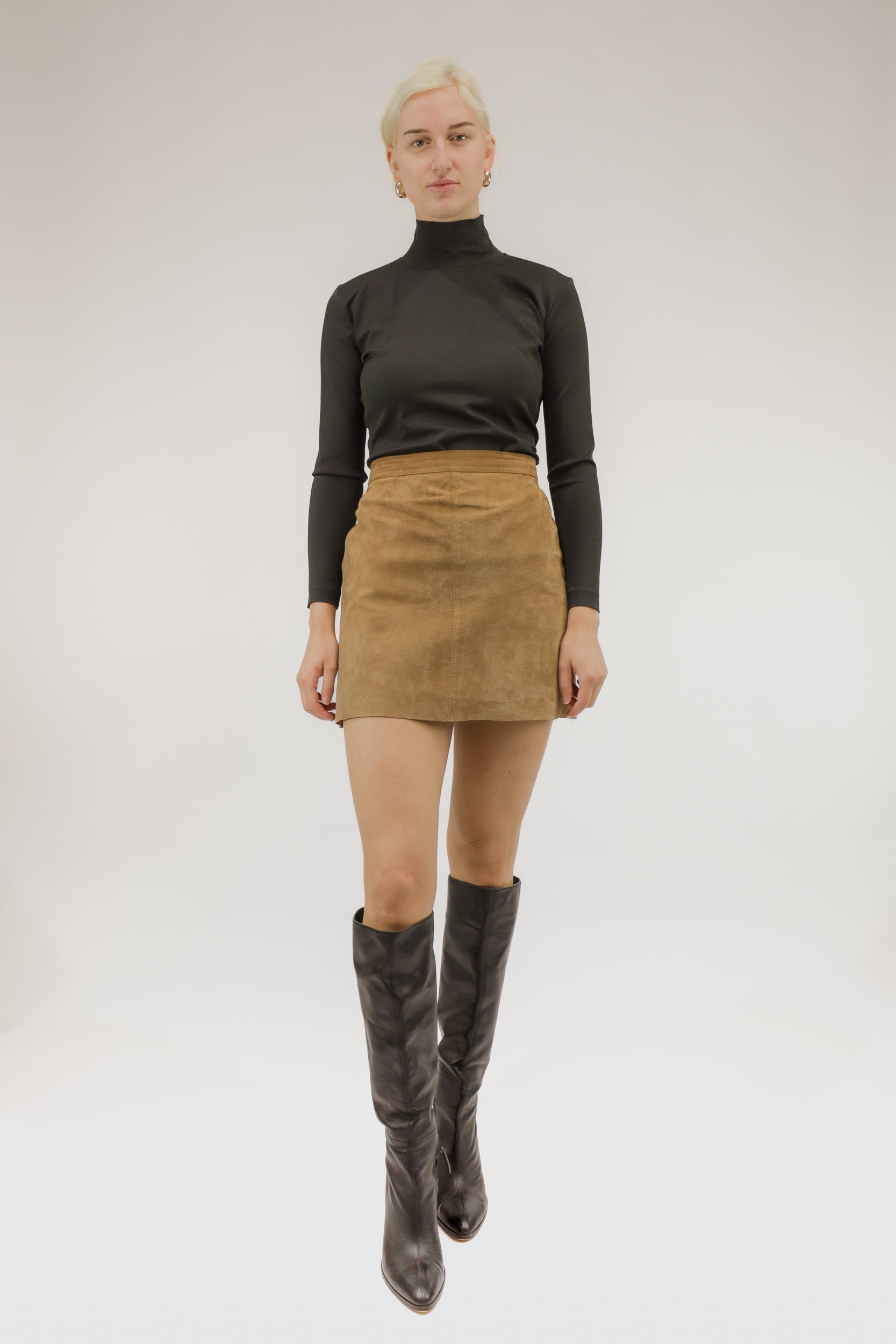 Model draagt vintage suède rok met soepele pasvorm – vooraanzicht.