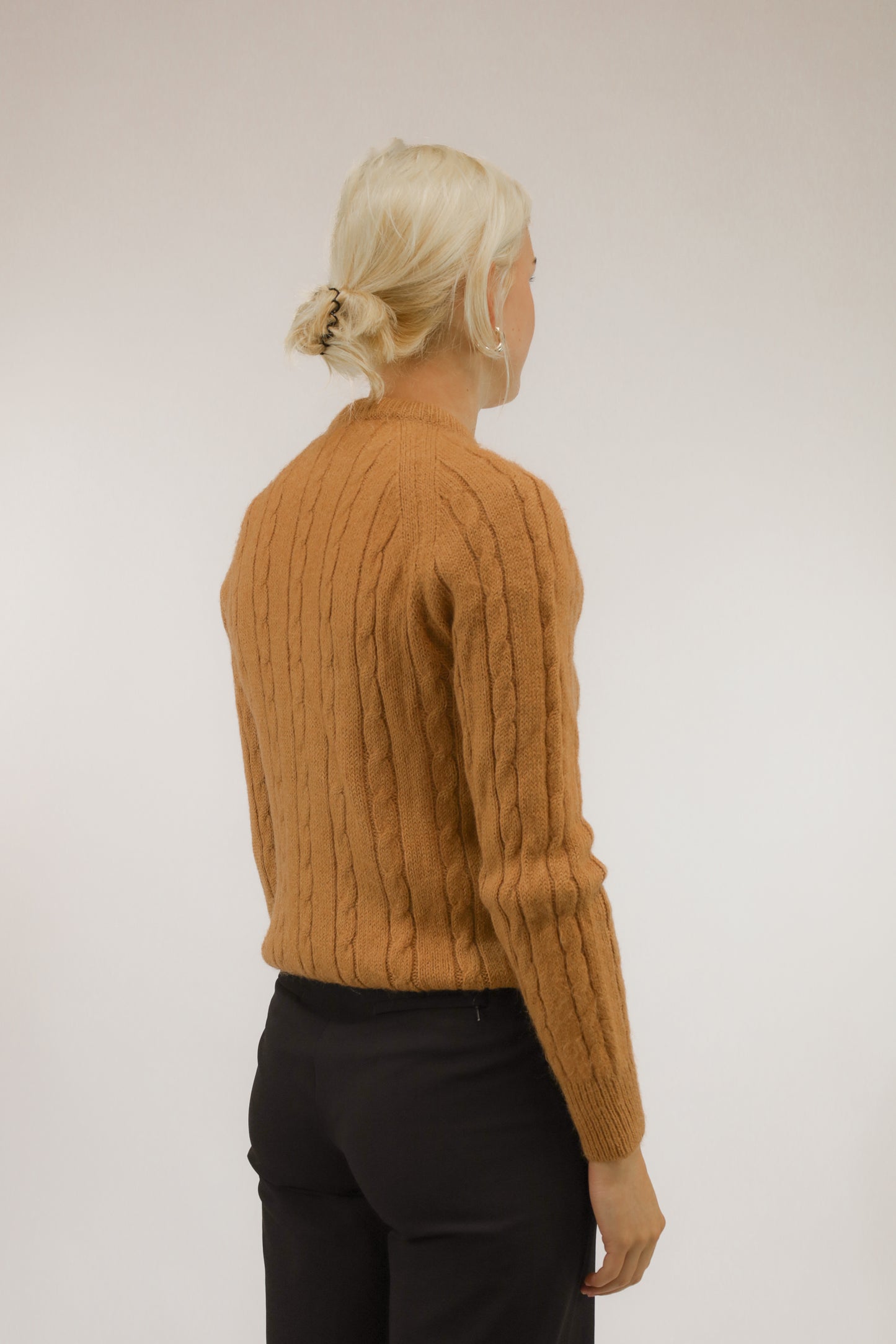 Achteraanzicht van model met cognacbruine trui van wolmix met raglanmouwen