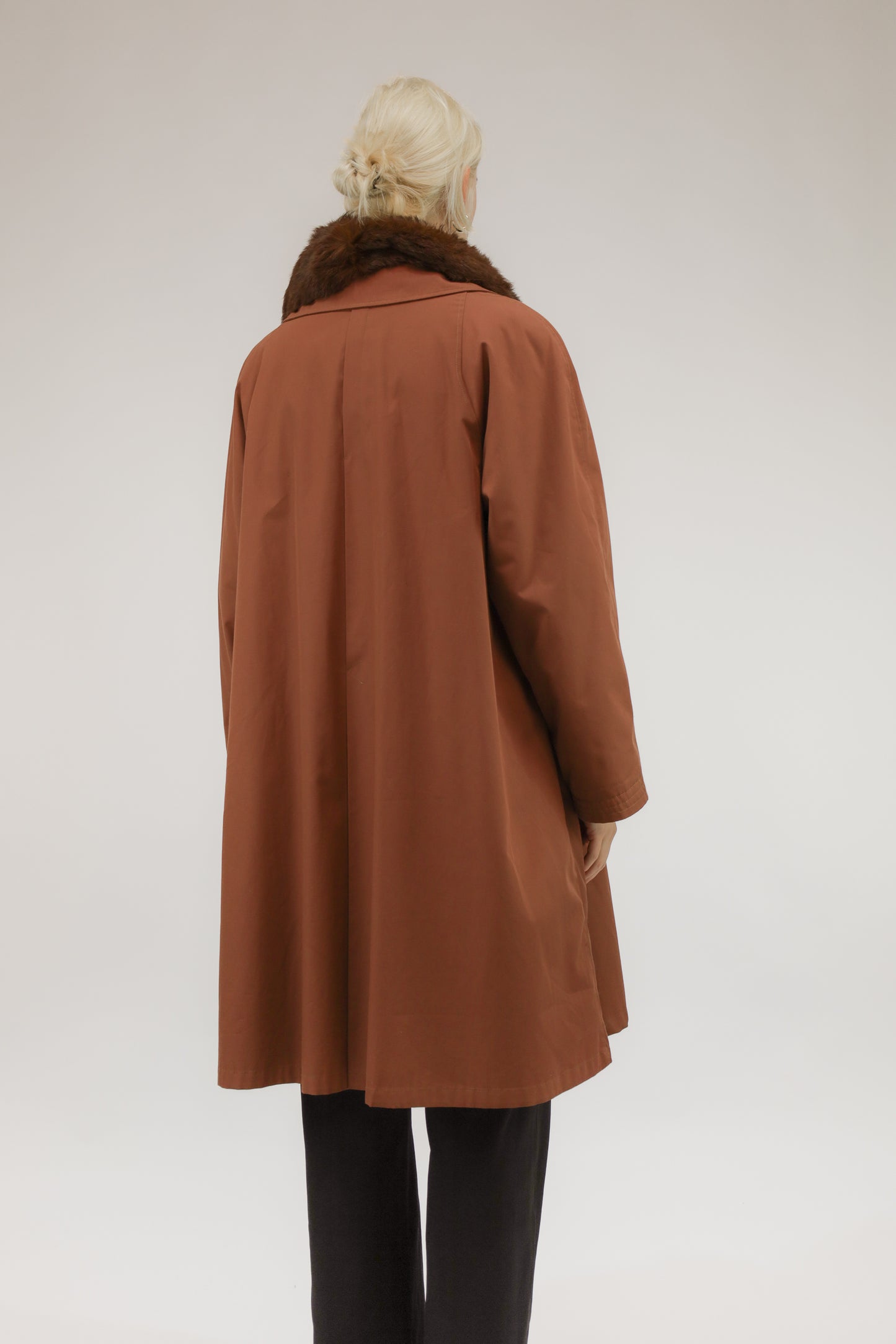 Model van achteren met vintage roestkleurige regenjas van Macri Raincoats & Jackets – halflang silhouet.