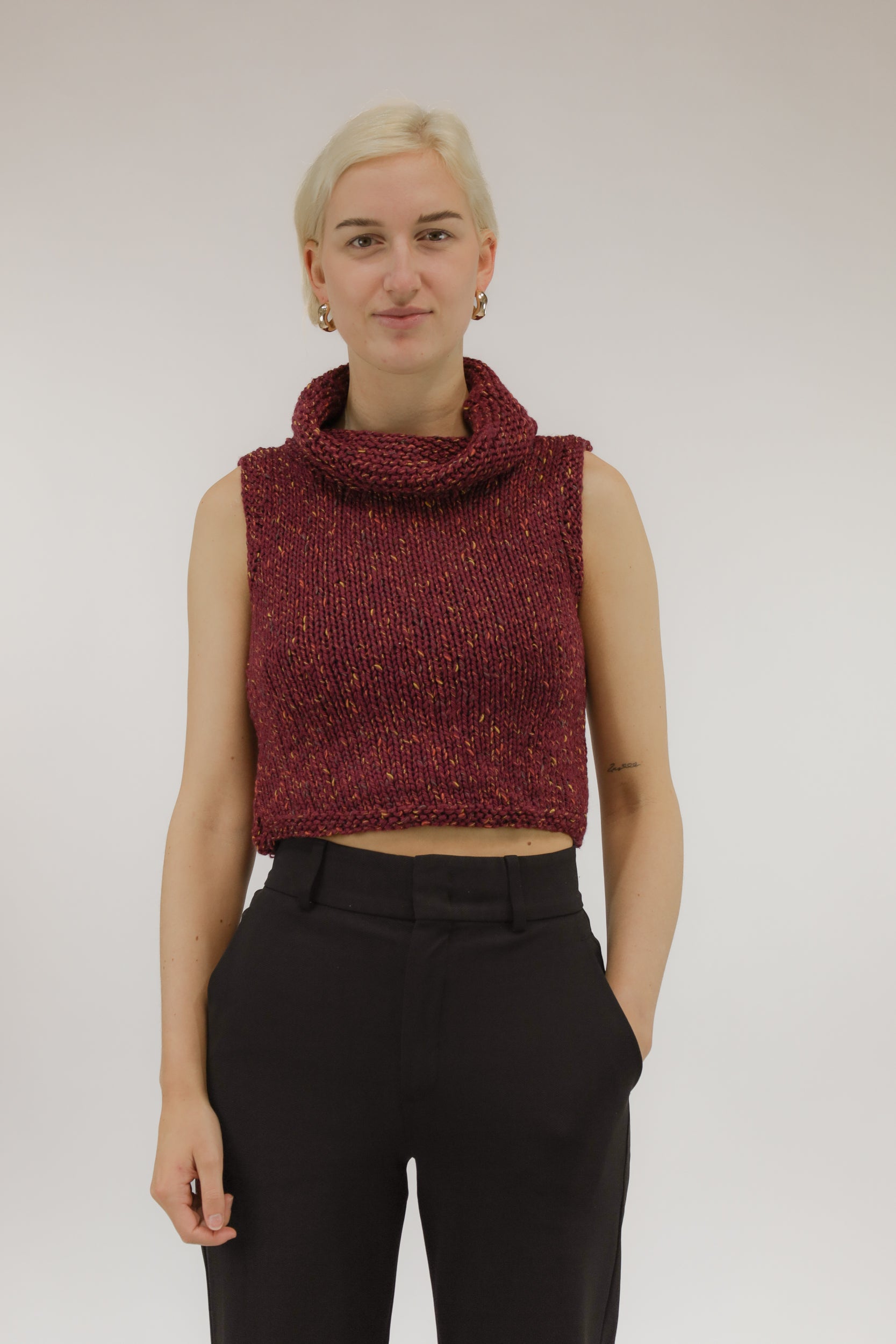 Vooraanzicht van model met oranje-zalmkleurige vintage gebreide top met col.