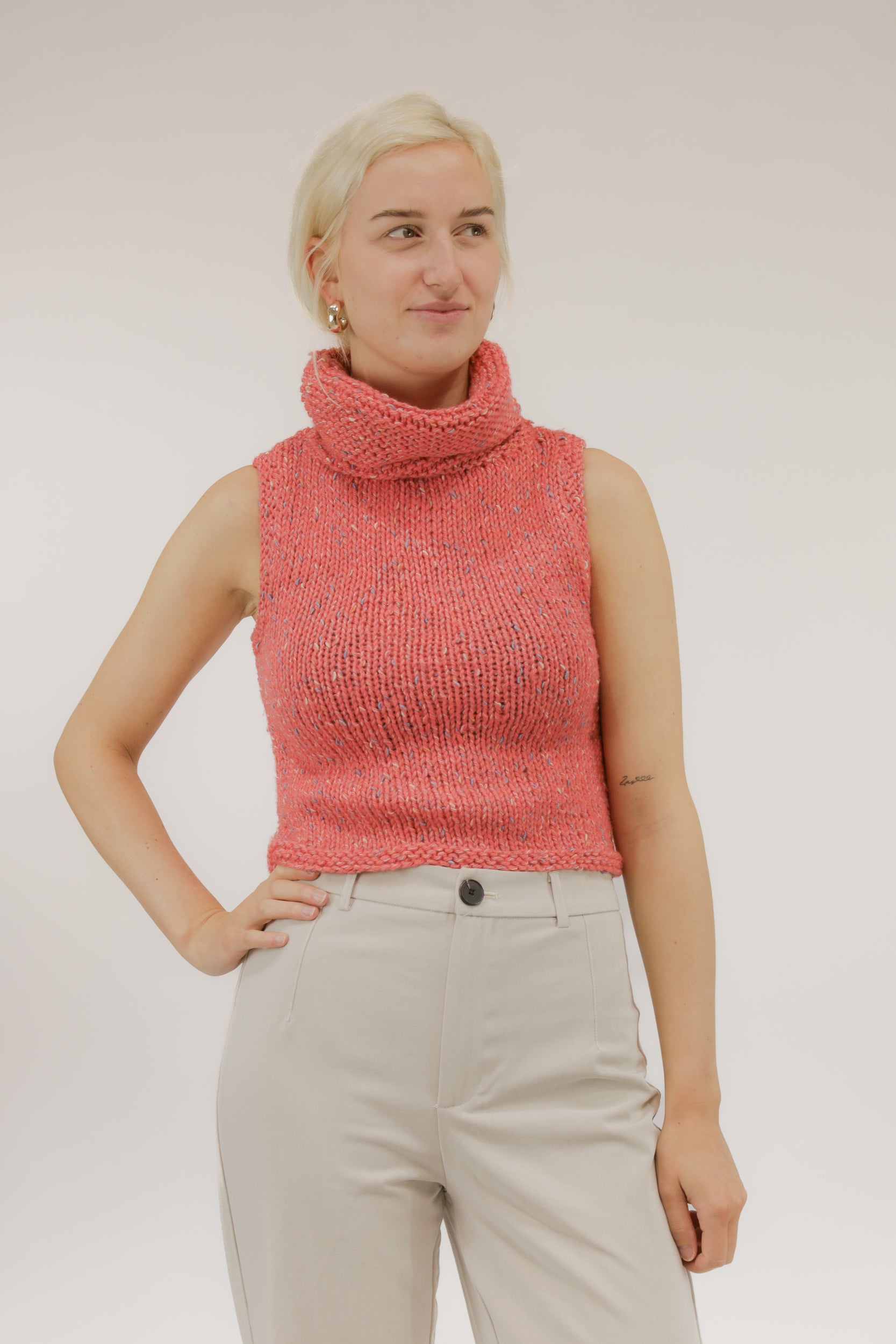 Vooraanzicht van model met oranje-zalmkleurige vintage gebreide top met col.