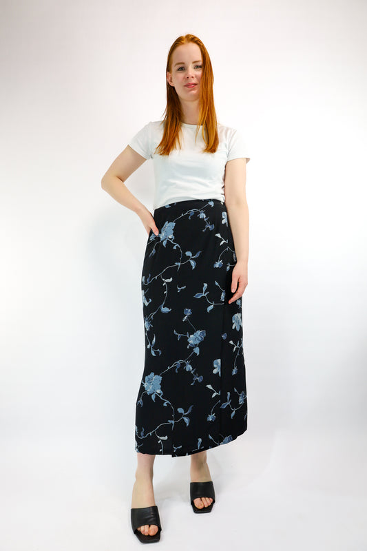 Model draagt vintage donkerblauwe wikkelrok met bloemenpatroon – vooraanzicht