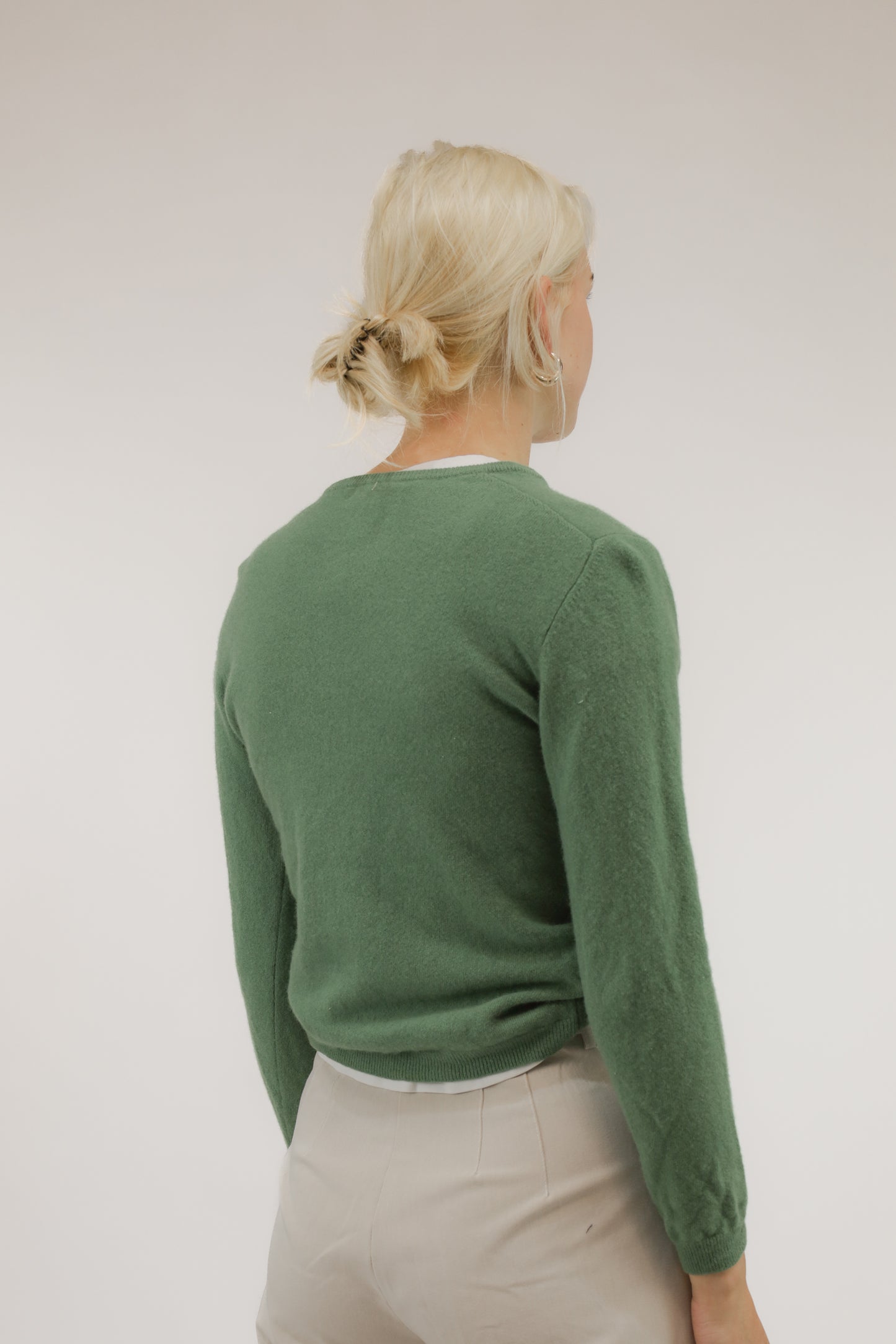 Model van achteren met groene basic wollen trui – fijn breisel en klassieke pasvorm zichtbaar