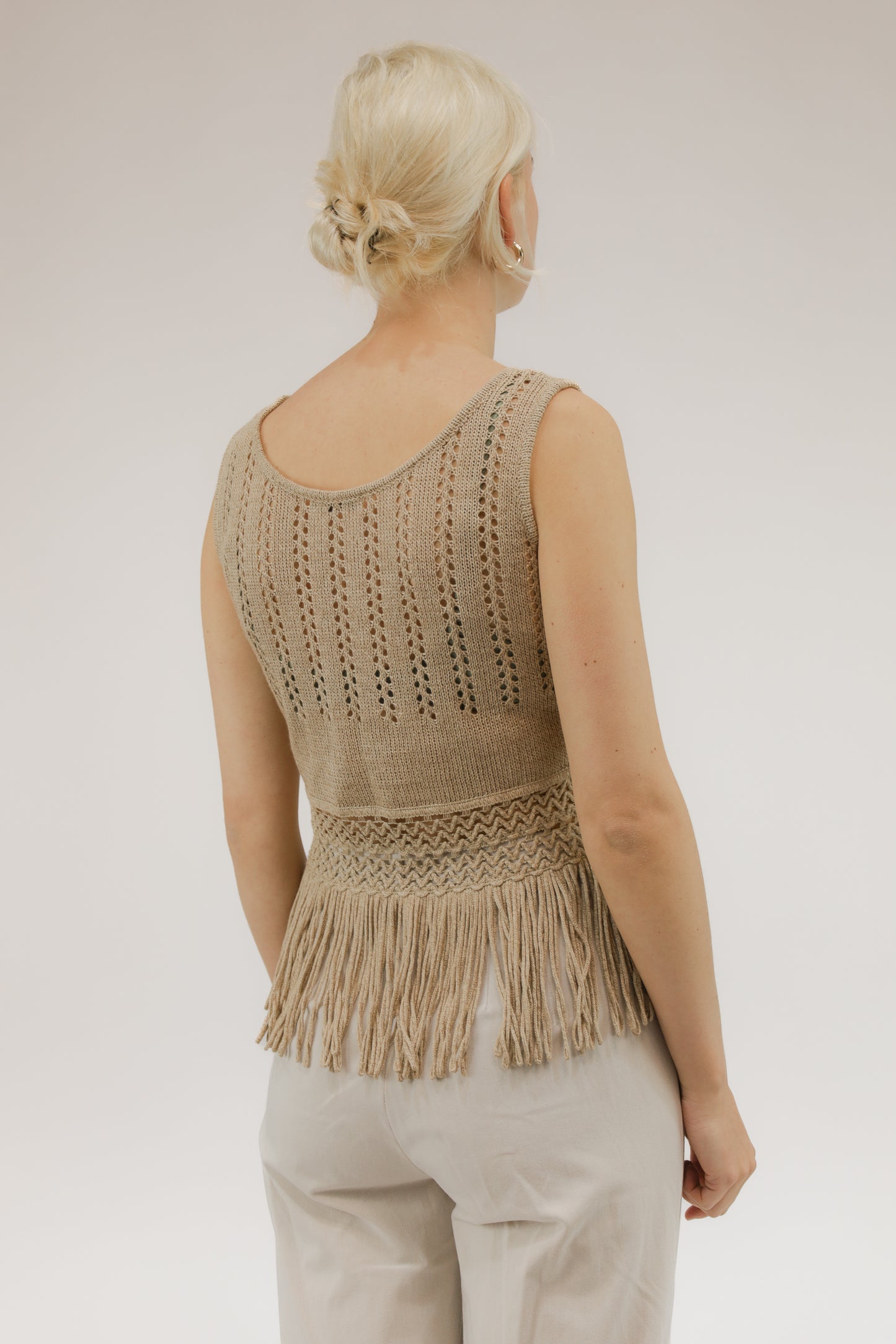 Achteraanzicht van model met gebreide vintage top van Canapa met franjes.