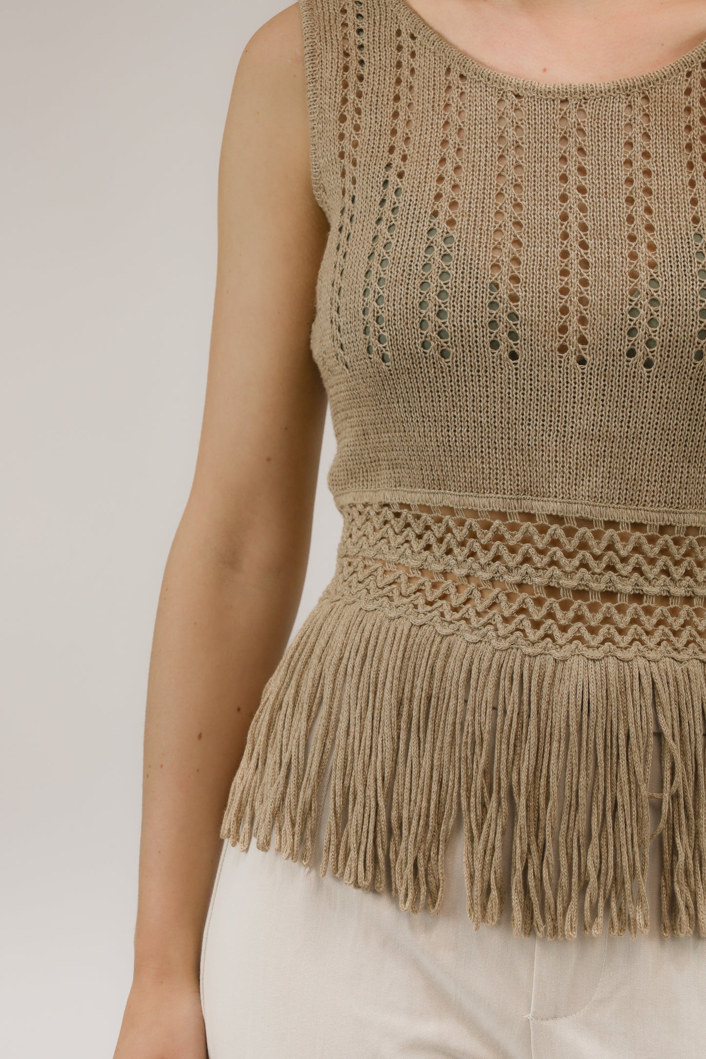 Detailopname van hennepstructuur en open breisel van de Canapa top.