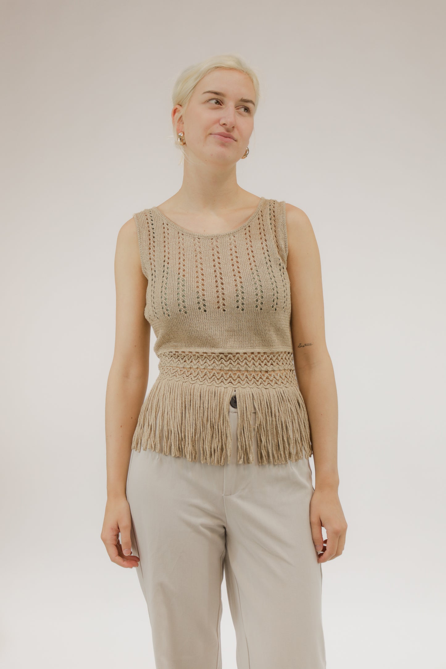 Vooraanzicht van model met open geweven vintage top van Canapa met franjes aan de onderkant.
