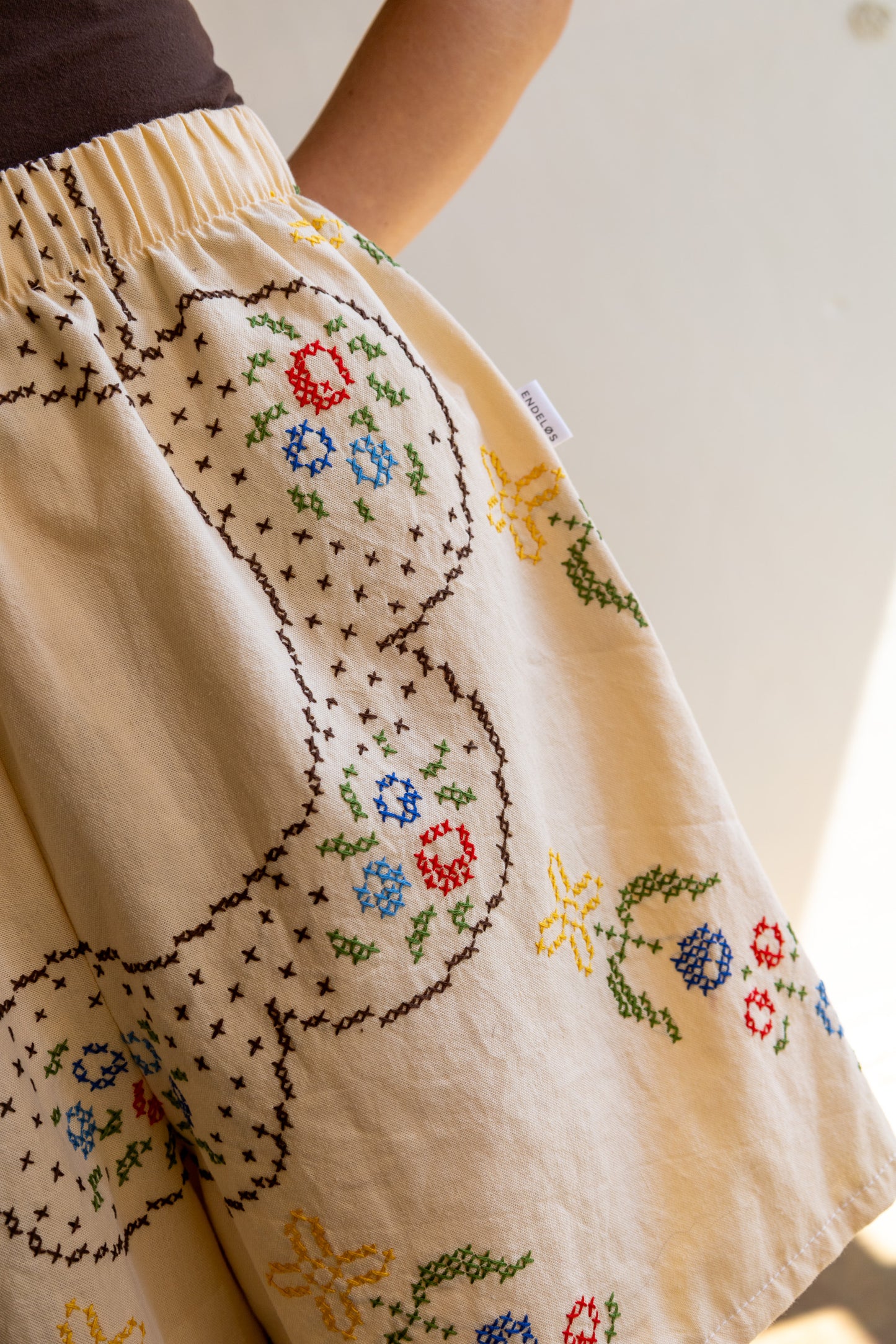 Detail van geborduurd kruisstekenmotief op vintage tafelkleed.