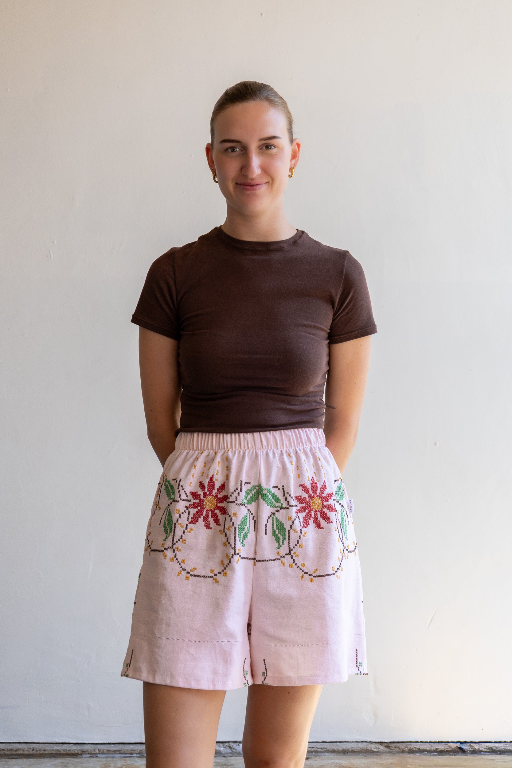 Handgemaakte short van een geborduurd vintage tafelkleed met elastische tailleband en kruisstekenmotief.