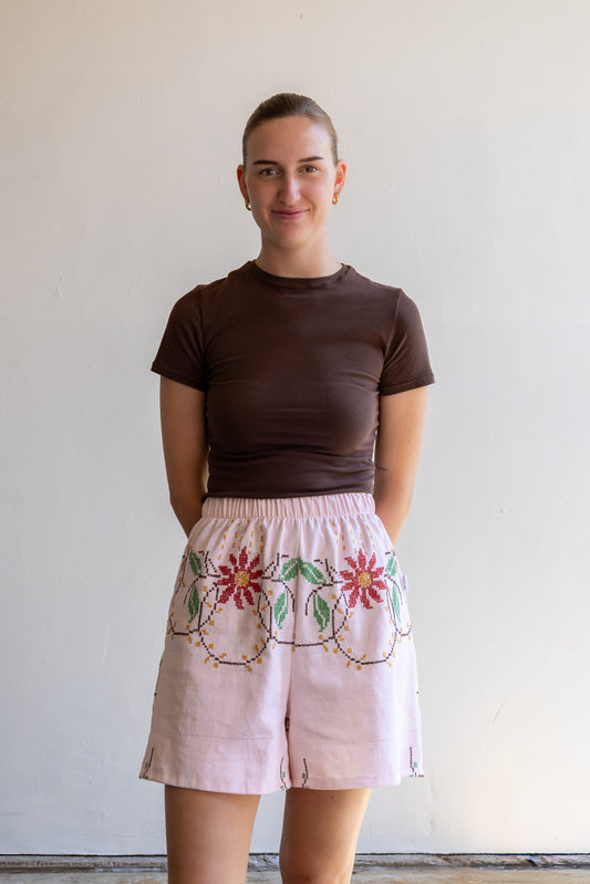 Handgemaakte short van een geborduurd vintage tafelkleed met elastische tailleband en kruisstekenmotief.