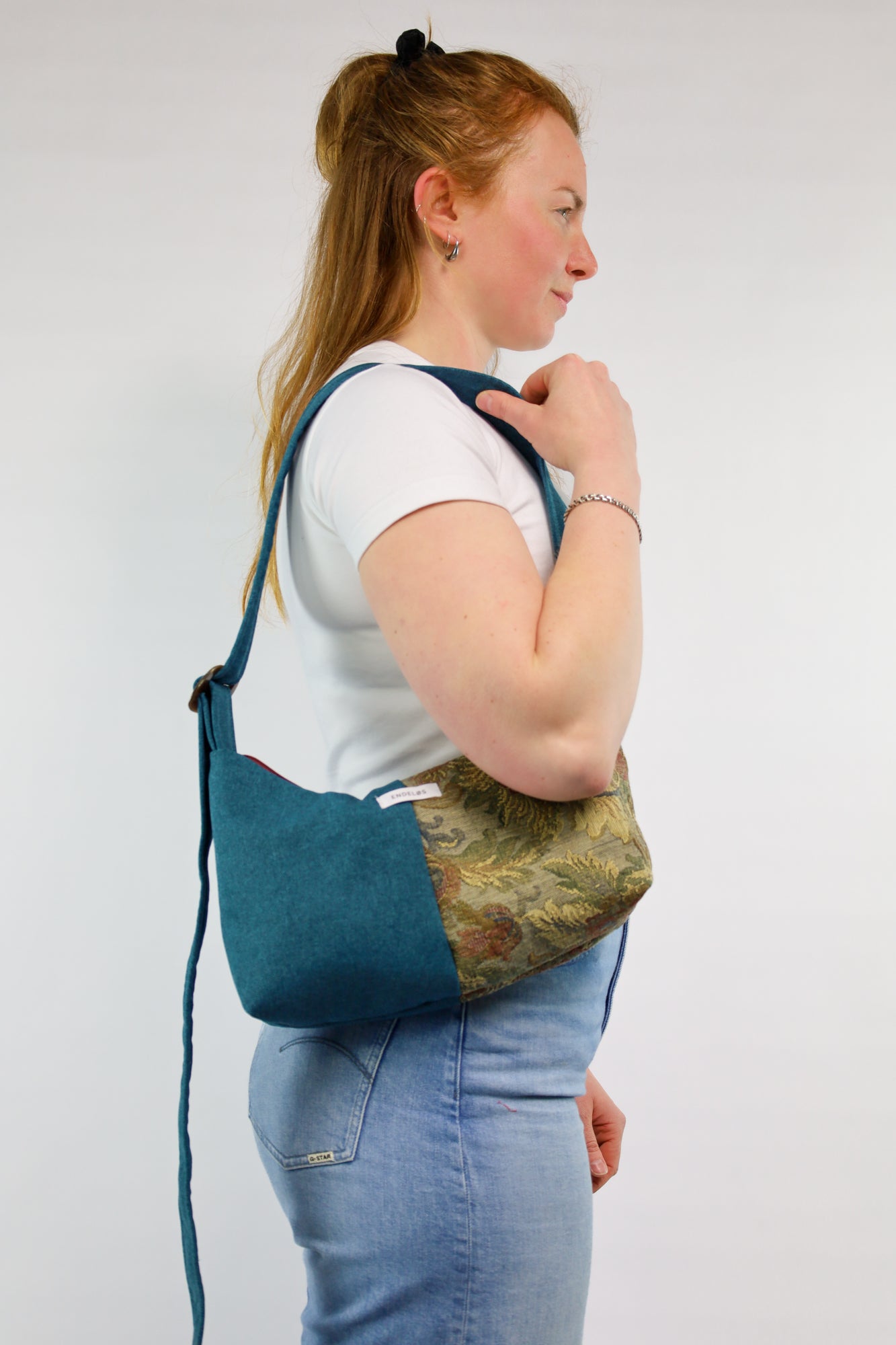 Crossbody bag van tweedehands gordijnstof, gedragen over de schouder