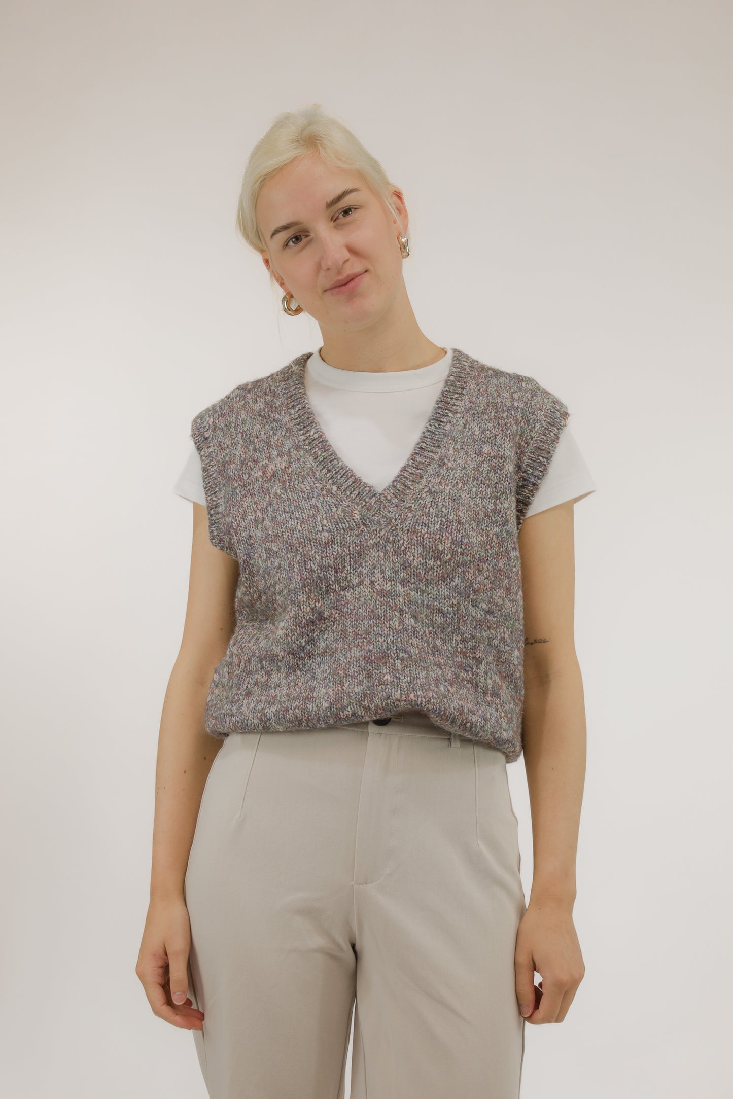 Model draagt vintage spencer van melange garen in rood- en paarstinten – vooraanzicht, V-hals