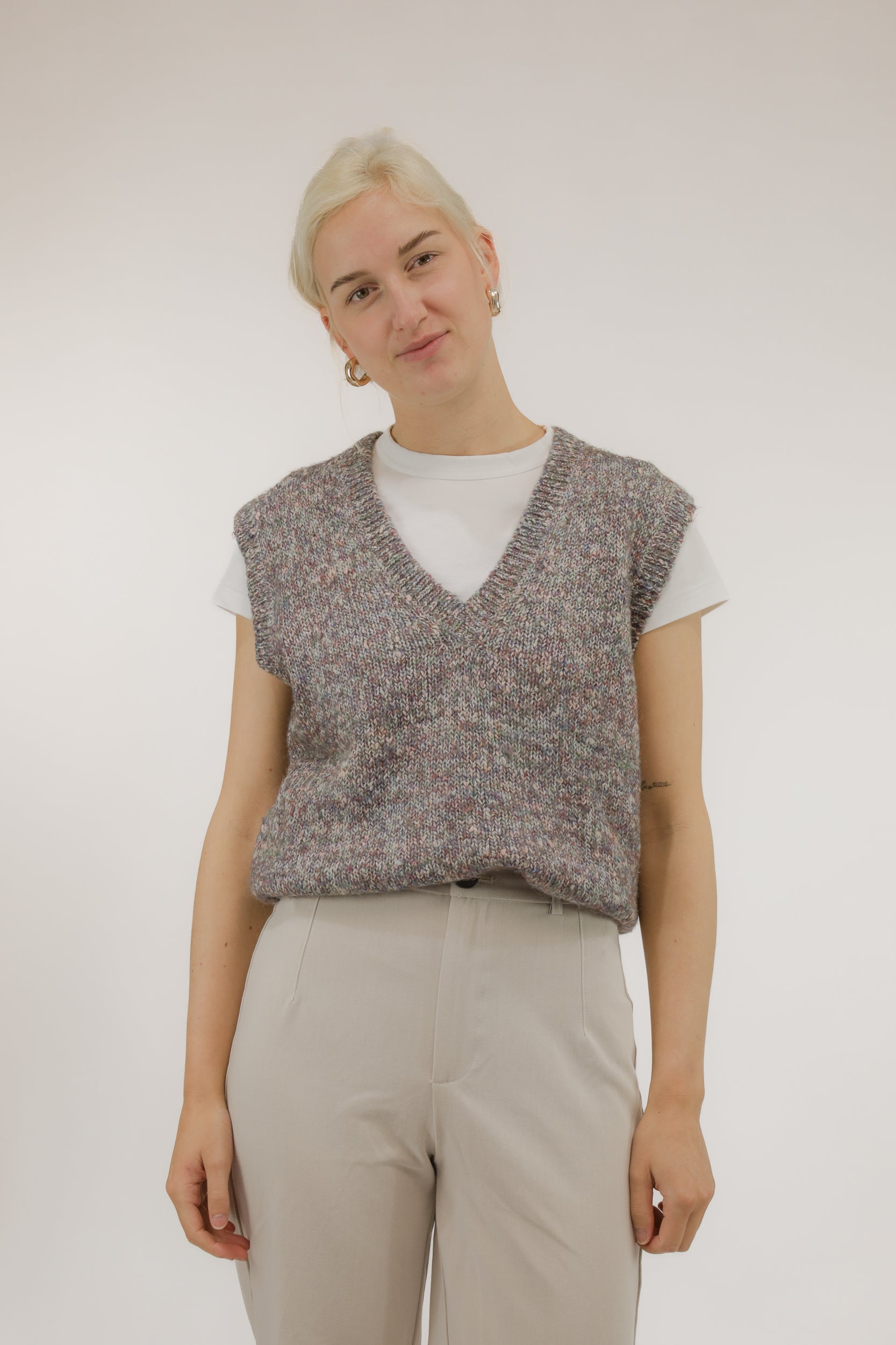 Model draagt vintage spencer van melange garen in rood- en paarstinten – vooraanzicht, V-hals