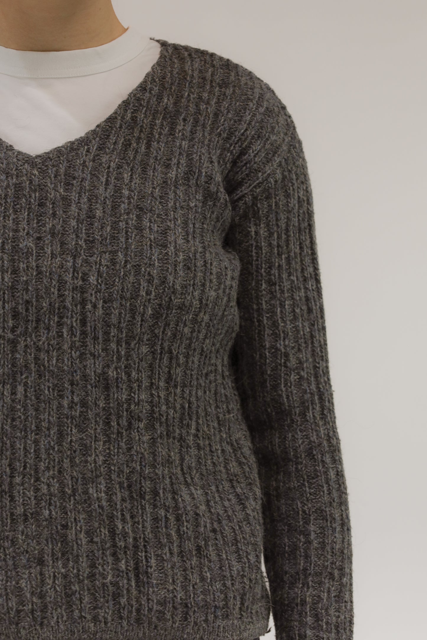 Detailopname van melange breisel en ingeweven streeppatroon van de mohair-alpaca trui.