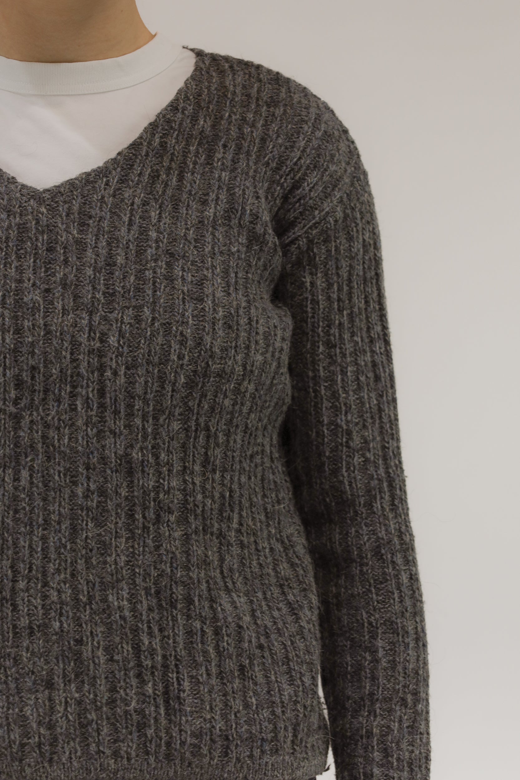 Detailopname van melange breisel en ingeweven streeppatroon van de mohair-alpaca trui.