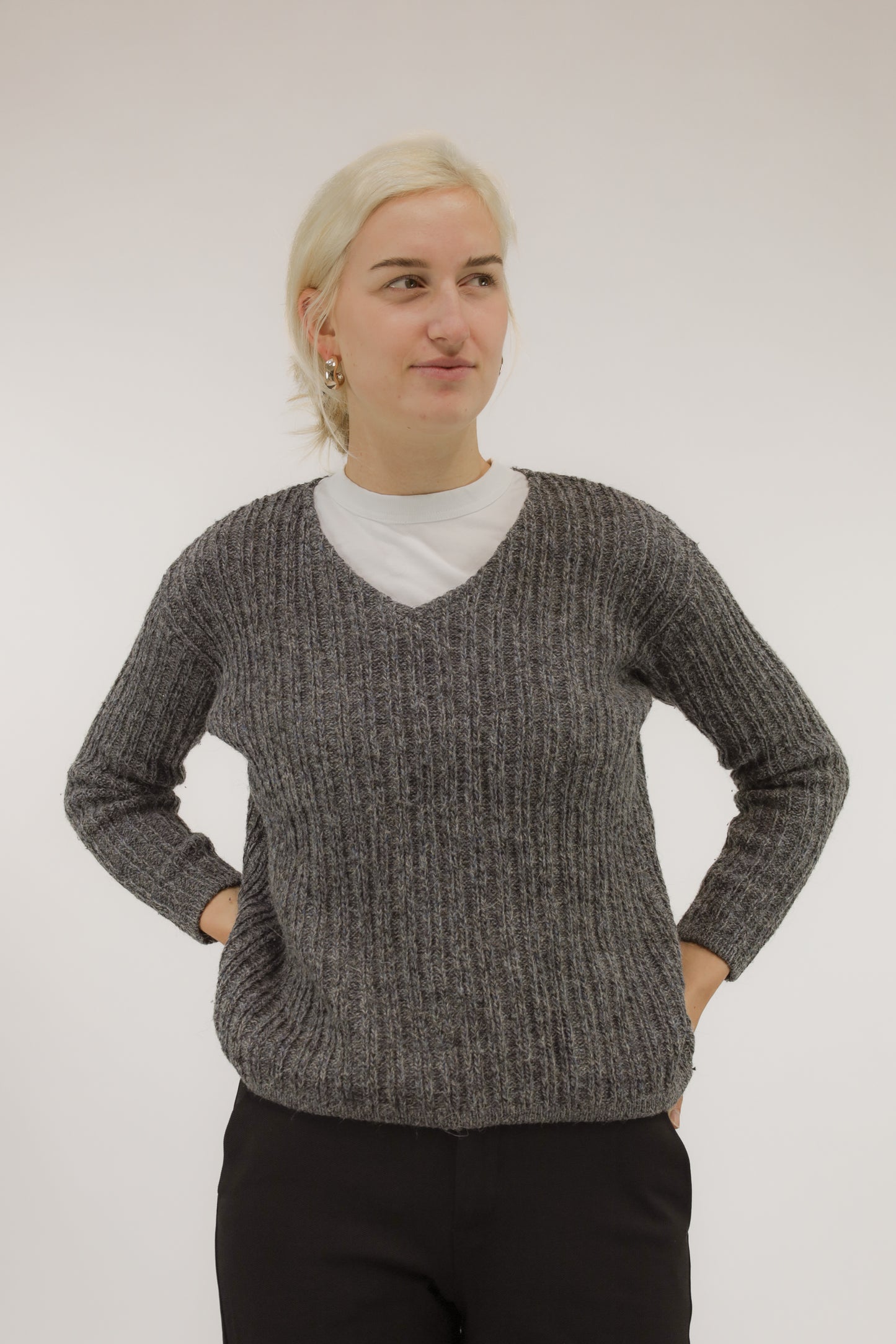 Vooraanzicht van model met handgebreide vintage trui van mohair- en alpacamix in grijs-blauw melange met lichte V-hals.