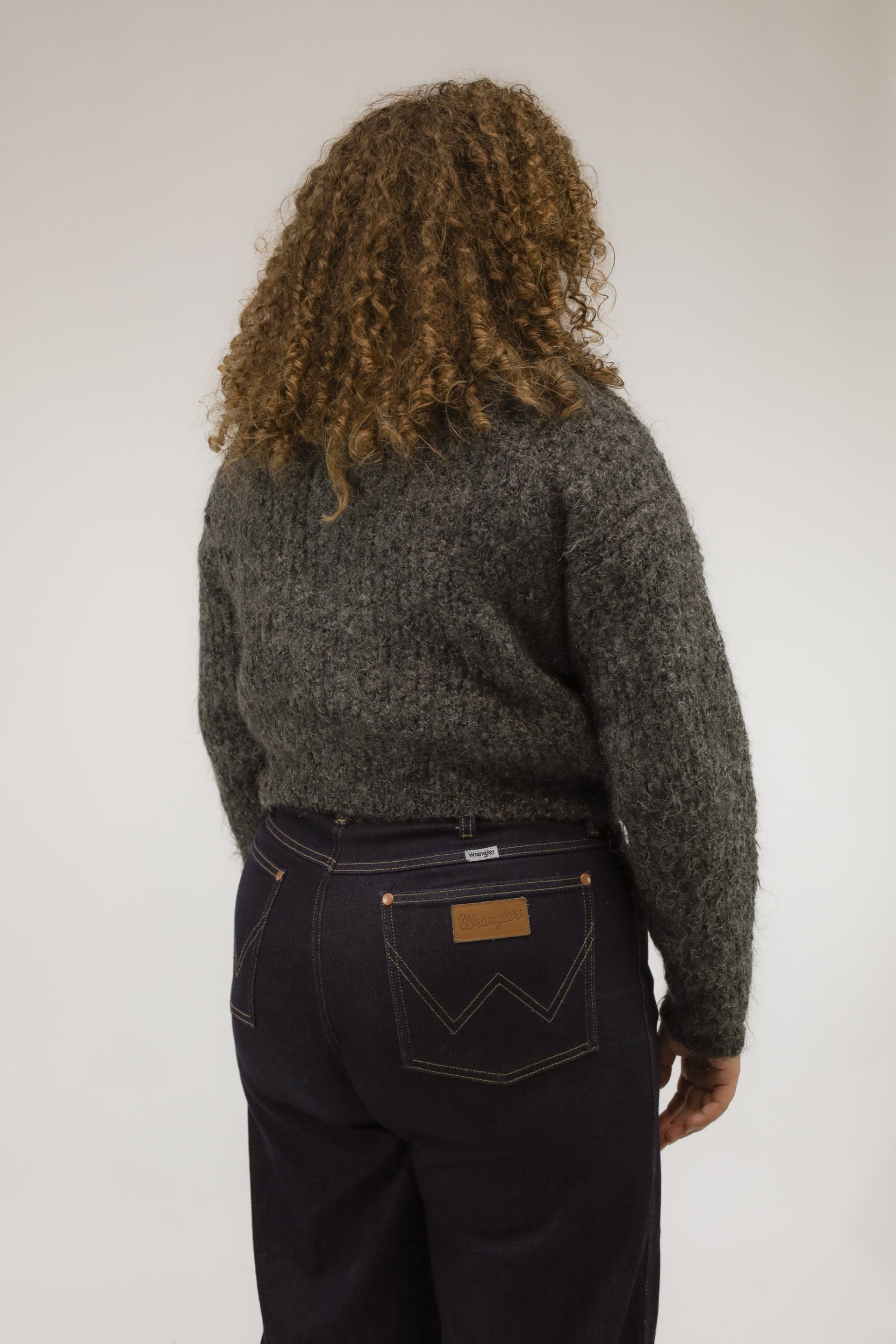 Achteraanzicht van model met kort grijs vintage vest van mohairmix.