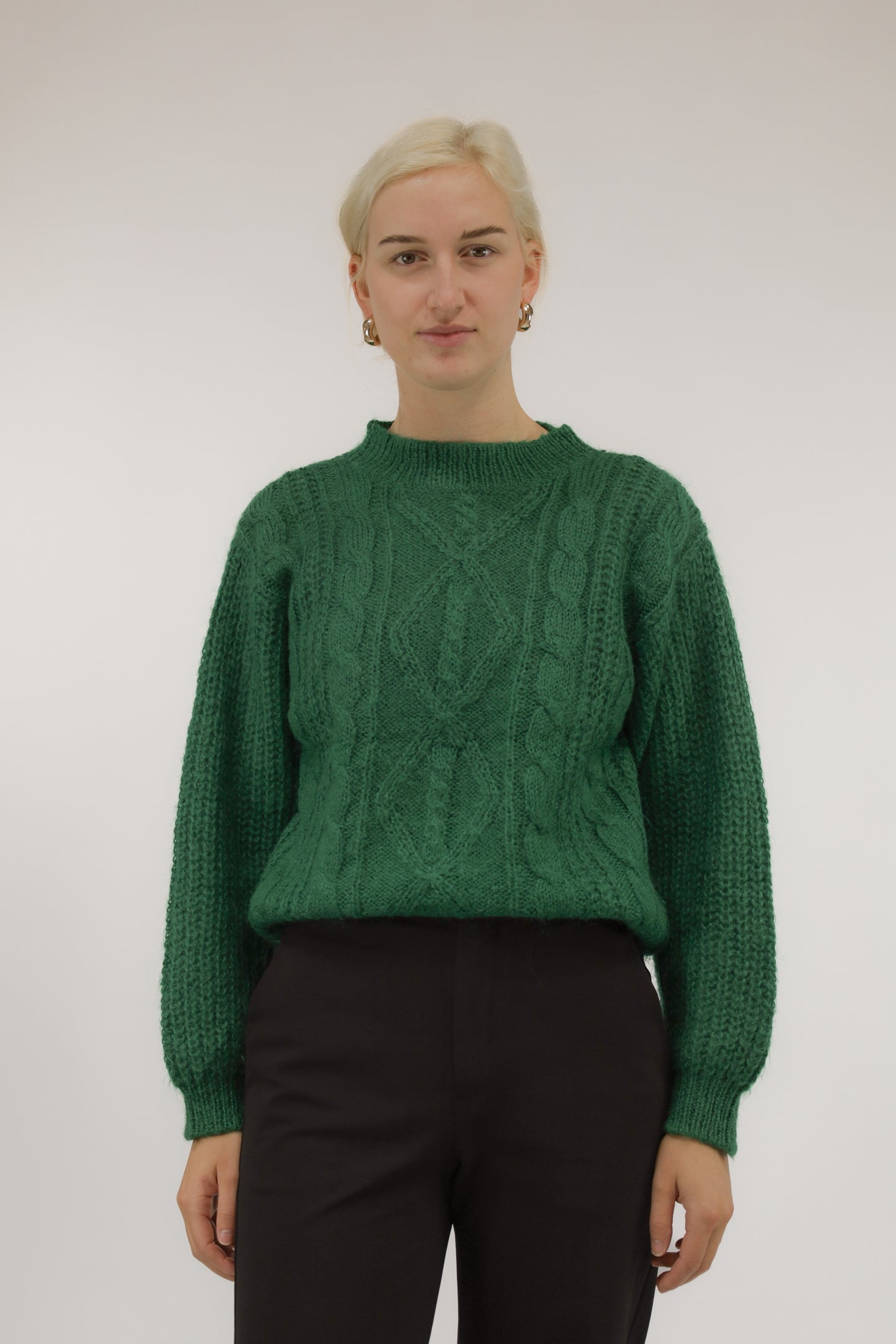 Model draagt vintage groene mohair trui met ingeweven kabeldessin – vooraanzicht, ronde halslijn.