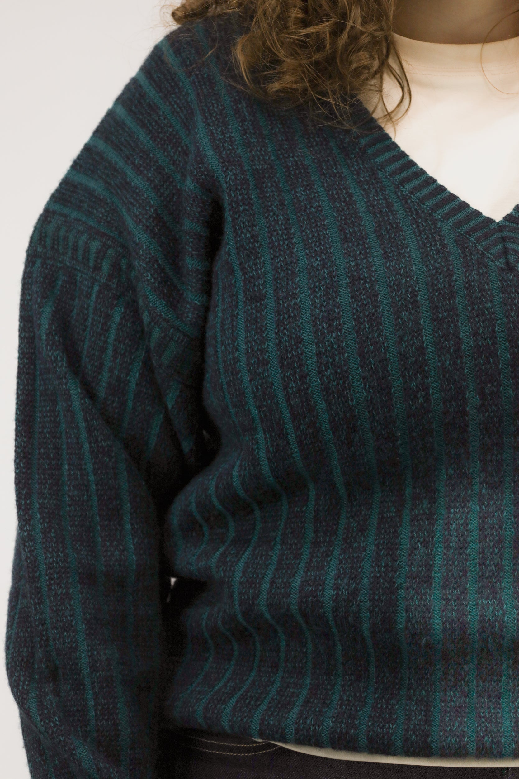 Detailopname van ingebreid streeppatroon en structuur van de trui.